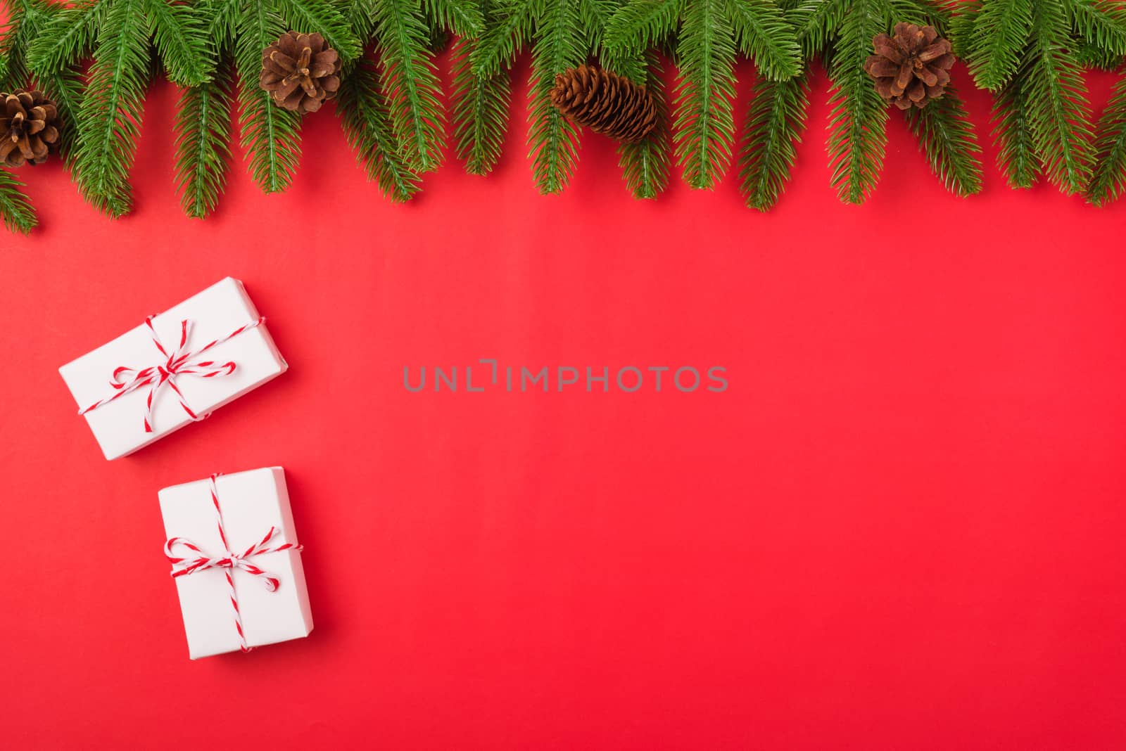 Happy new year or christmas day top view flat lay fir tree branches and gift box, decoration on red background with copy space for your text