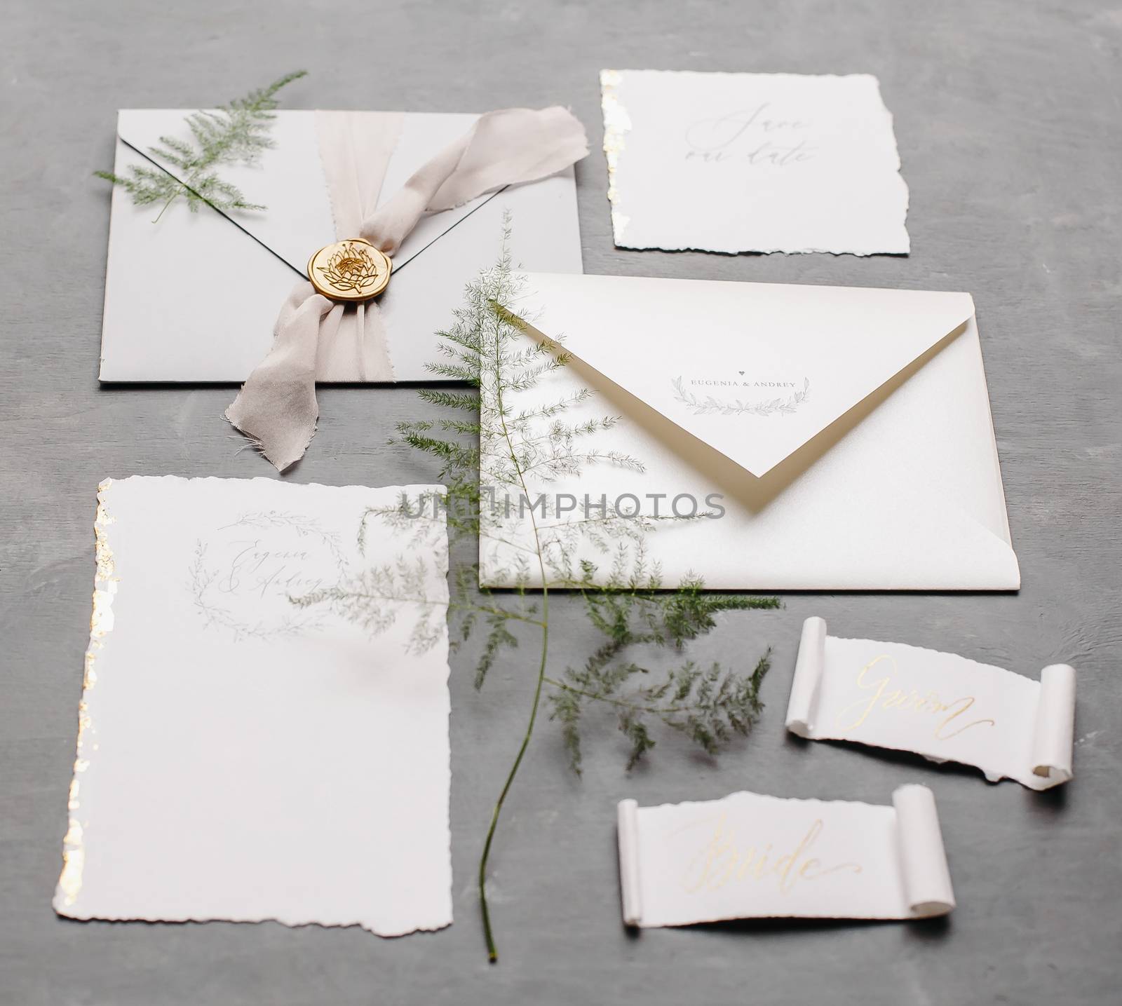 Wedding details flat lay. Wedding invitation and scroll paper. Bottle with fragrance. Simple bouquet. Ring box.