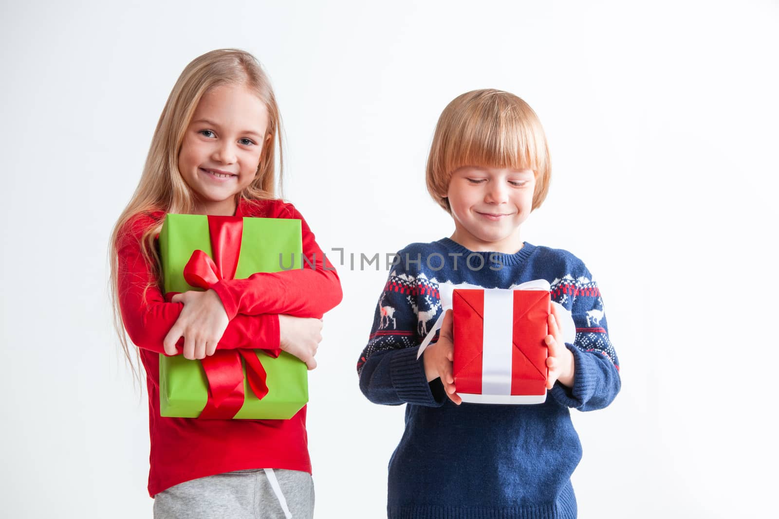 Portrait of two happy children with Christmas gift boxes on white background