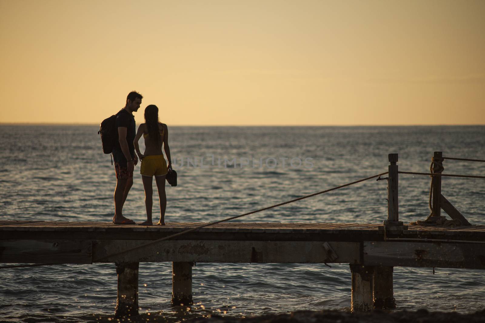 BAYAHIBE, DOMINICAN REPUBLIC 13 DECEMBER 2019: Young couple in love on the pier at susnset