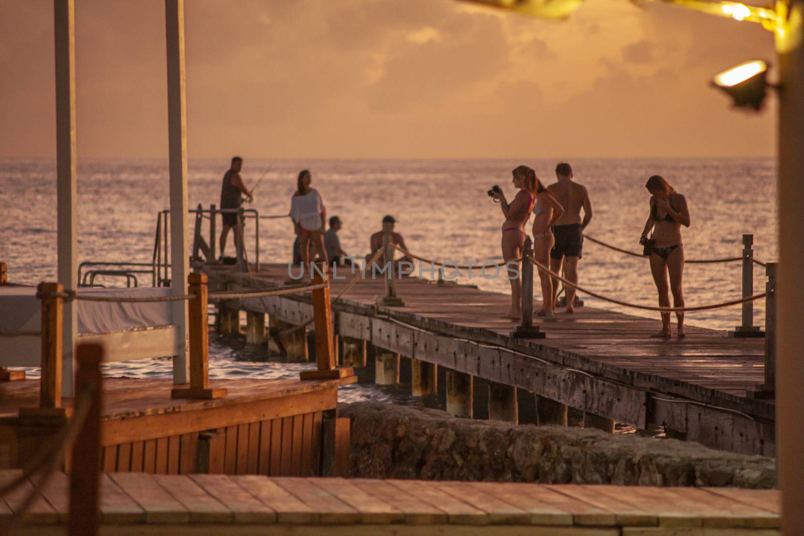 BAYAHIBE, DOMINICAN REPUBLIC 13 DECEMBER 2019: People on the pier at sunset