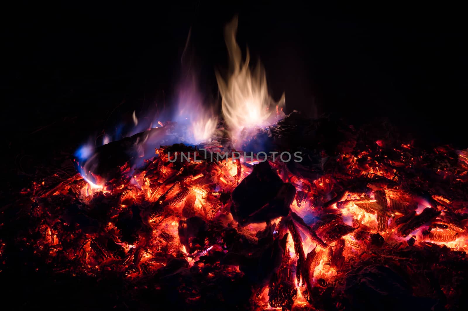 A low light long exposure photo of smouldering coals. by alexsdriver