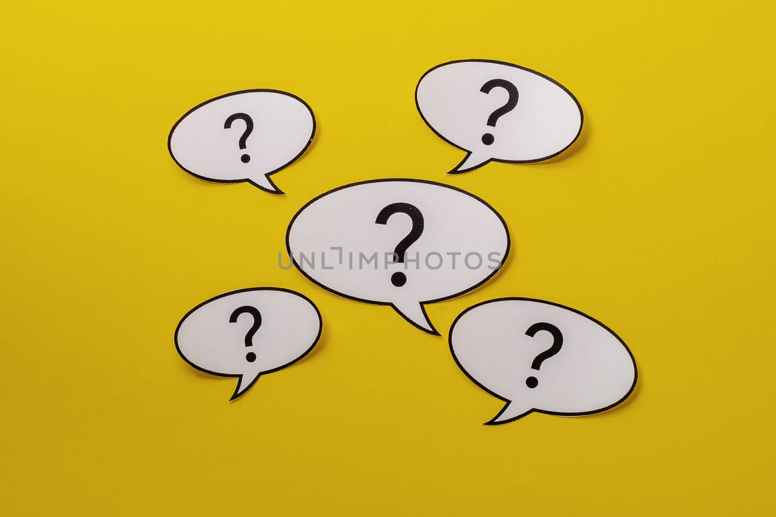 Five speech bubbles with question marks over a bright yellow background by sergii_gnatiuk
