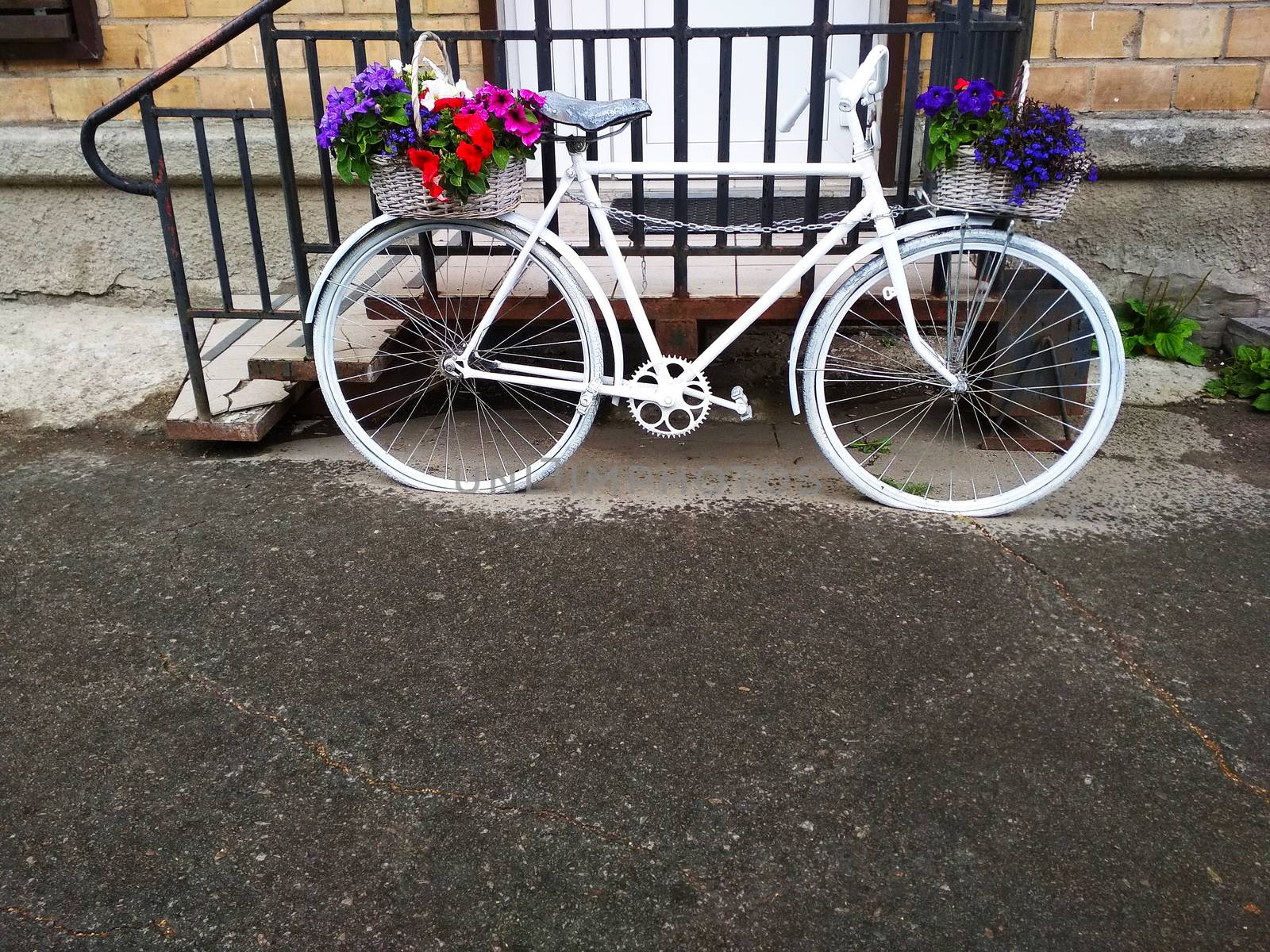 
A vintage two-wheeled Bicycle with flowers on it.