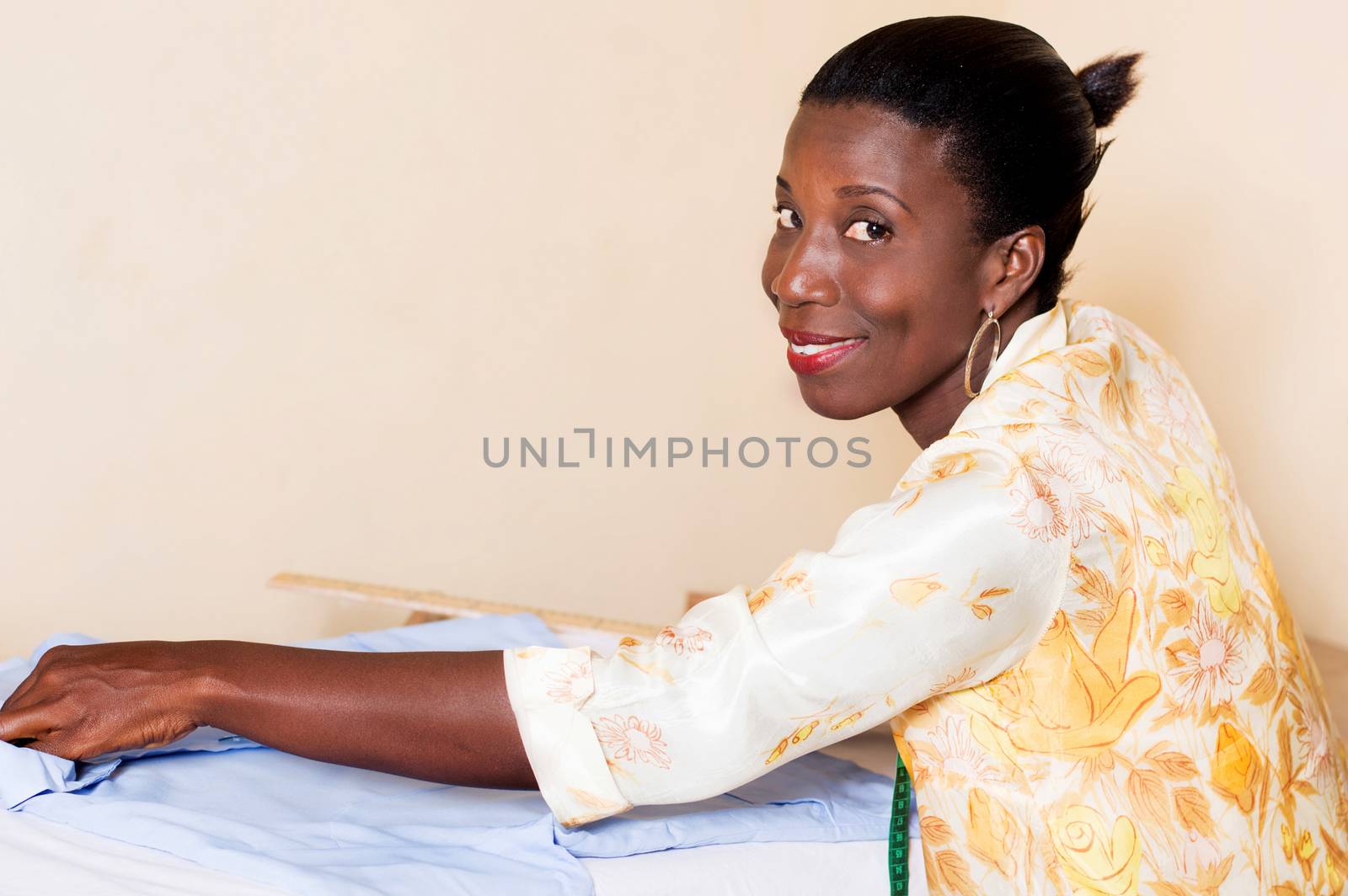 seamstress measure the length of a shirt lying on her table.