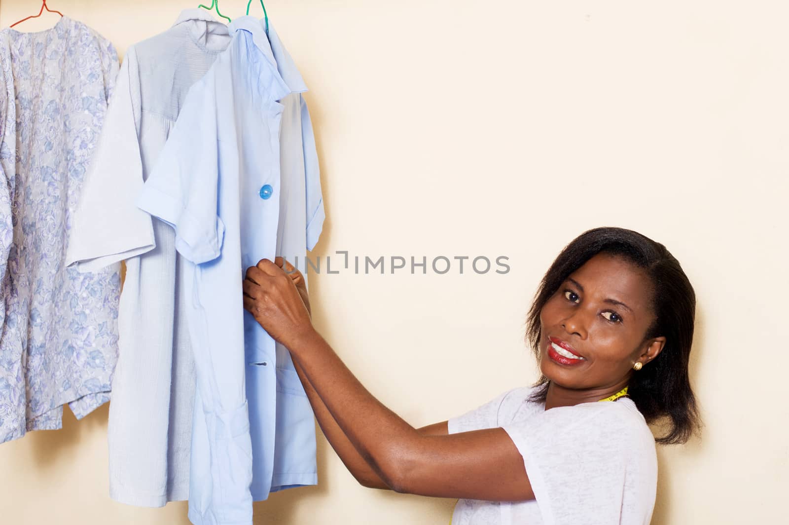 The sewing student arranges shirts sewn by putting the buttons.