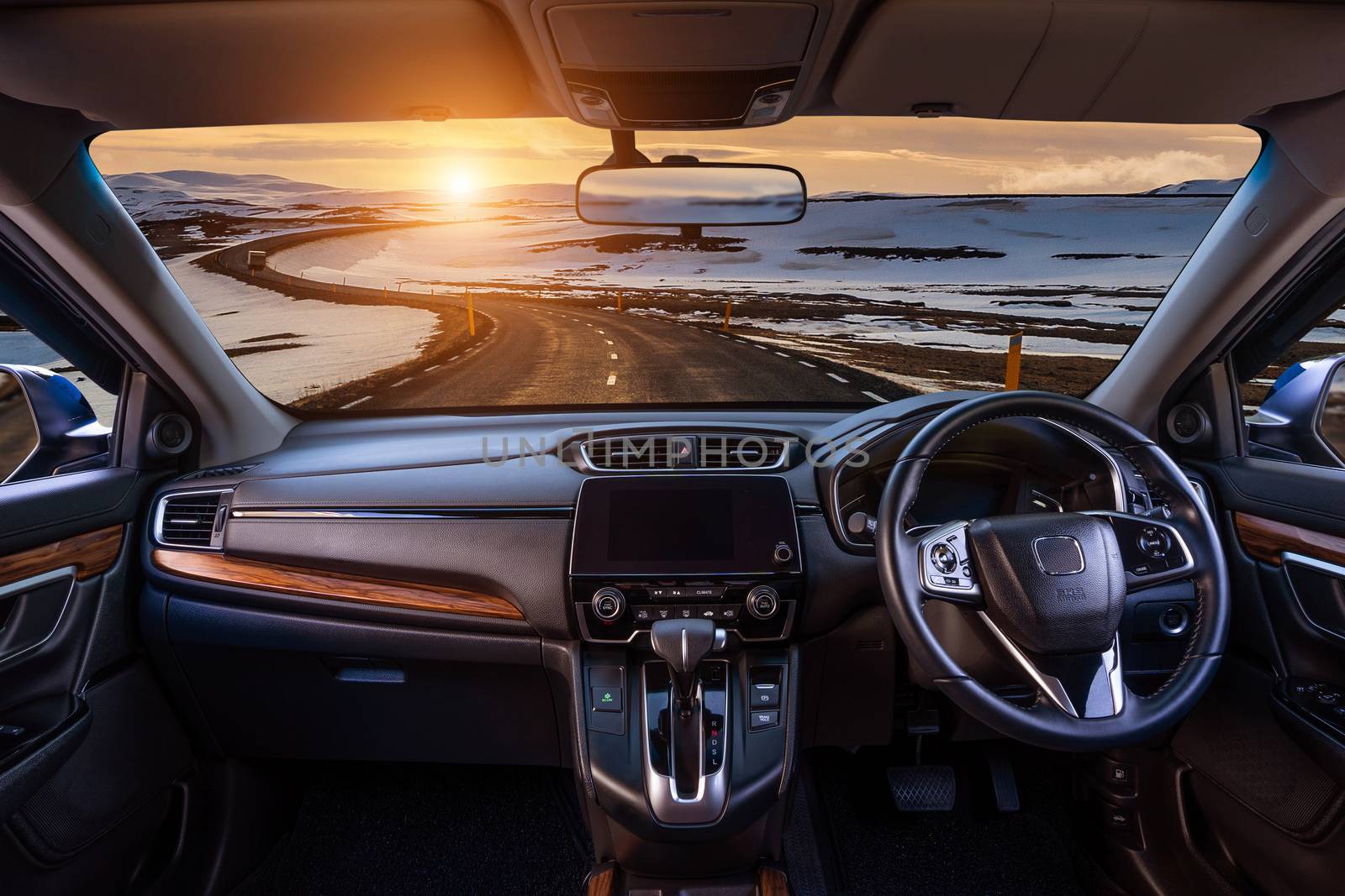 Looking through a car windshield with sunset and road in winter. Travel in car. by gutarphotoghaphy