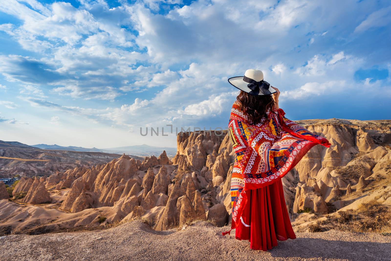 Woman standing on mountains in Cappadocia, Turkey. by gutarphotoghaphy