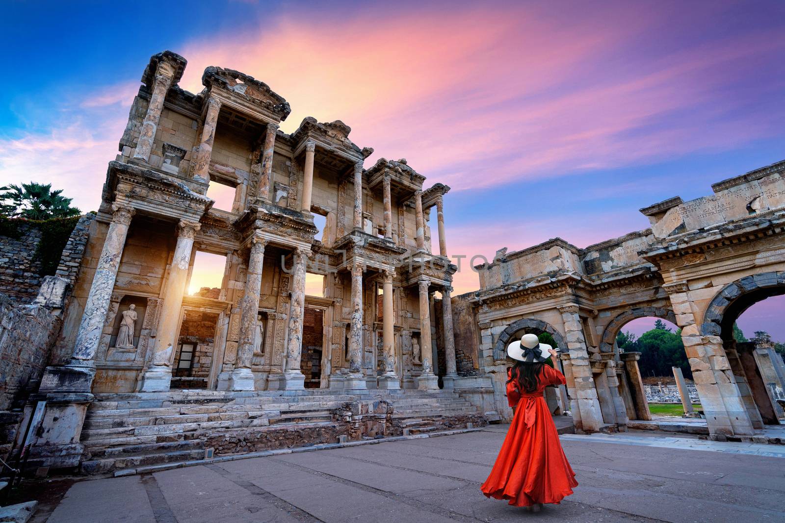 Woman standing in Celsus Library at Ephesus ancient city in Izmir, Turkey. by gutarphotoghaphy