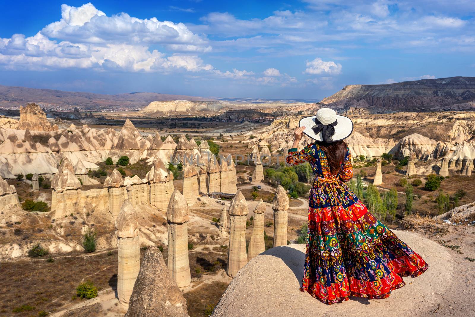 Woman in Bohemian dress standing on Love Valley in Cappadocia, Turkey.