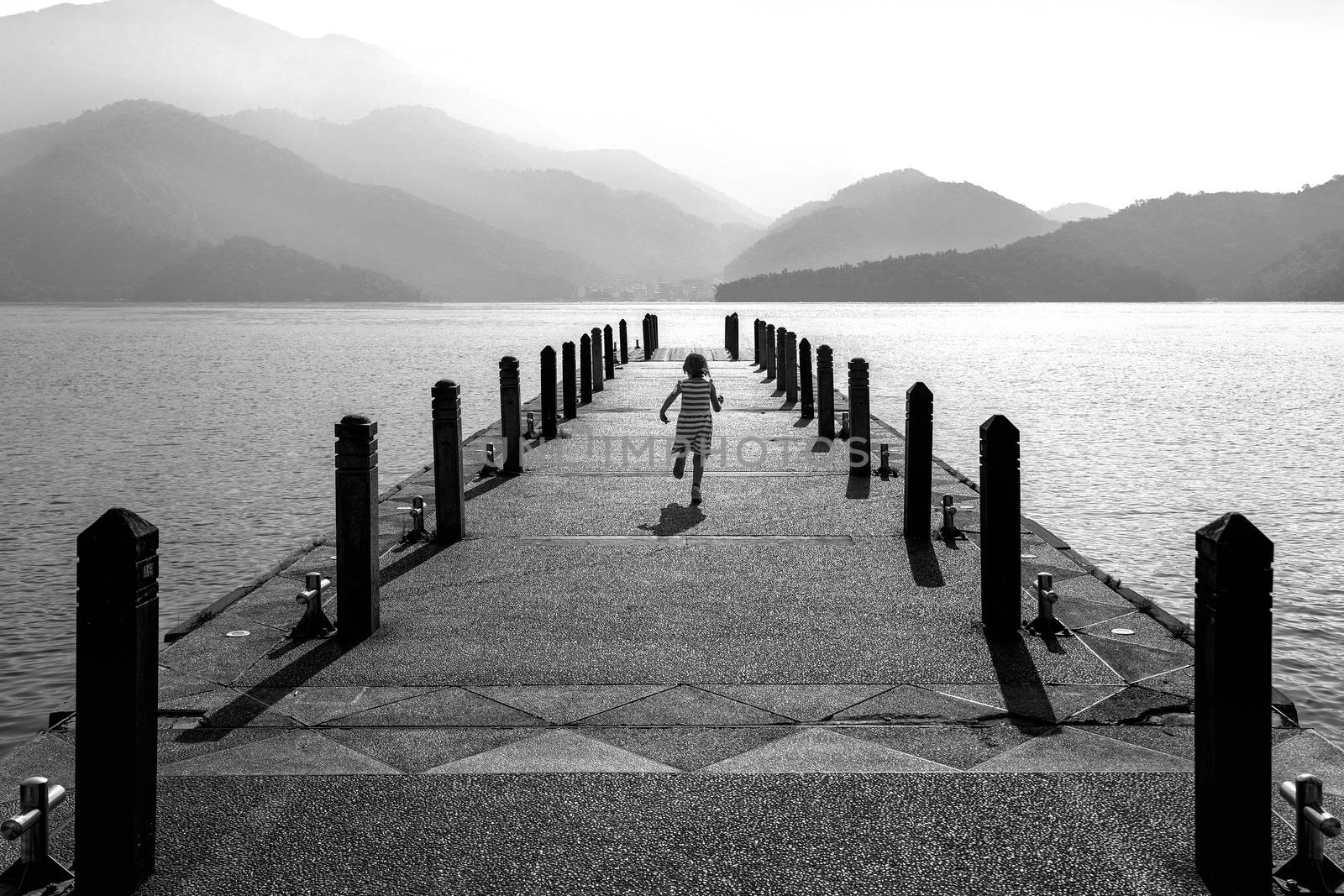 Black and white of Little girl running on pathway in Sun moon lake, Taiwan.