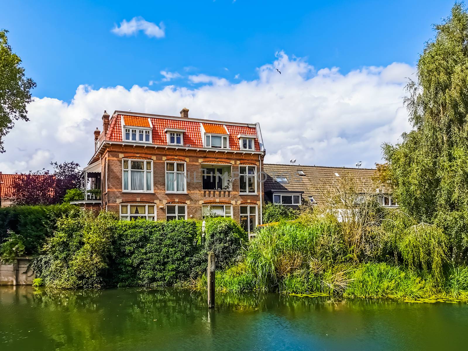 modern house at the water in dordrecht city, the netherlands, typical dutch cottage at the canal