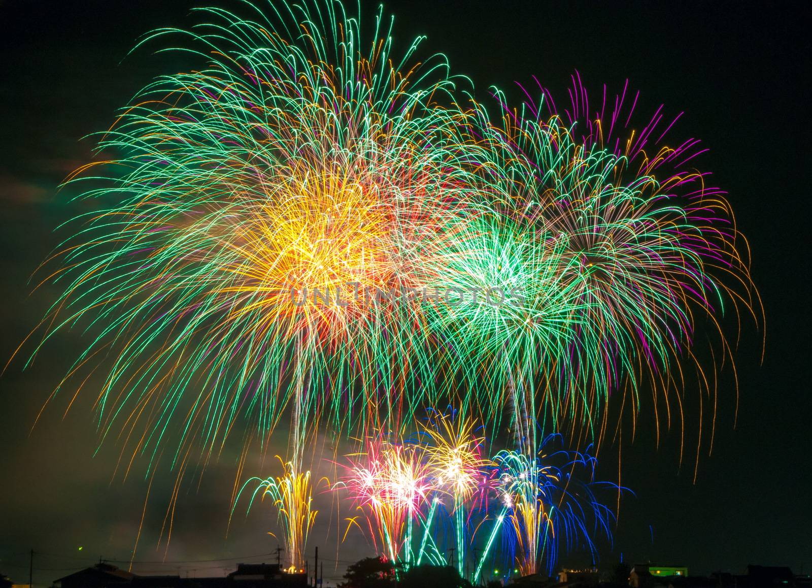 Colorful fireworks. Fireworks are a class of explosive pyrotechnic devices used for aesthetic and entertainment purposes. Visible noise due to low light, soft focus, shallow DOF, slight motion blur by Roman1030