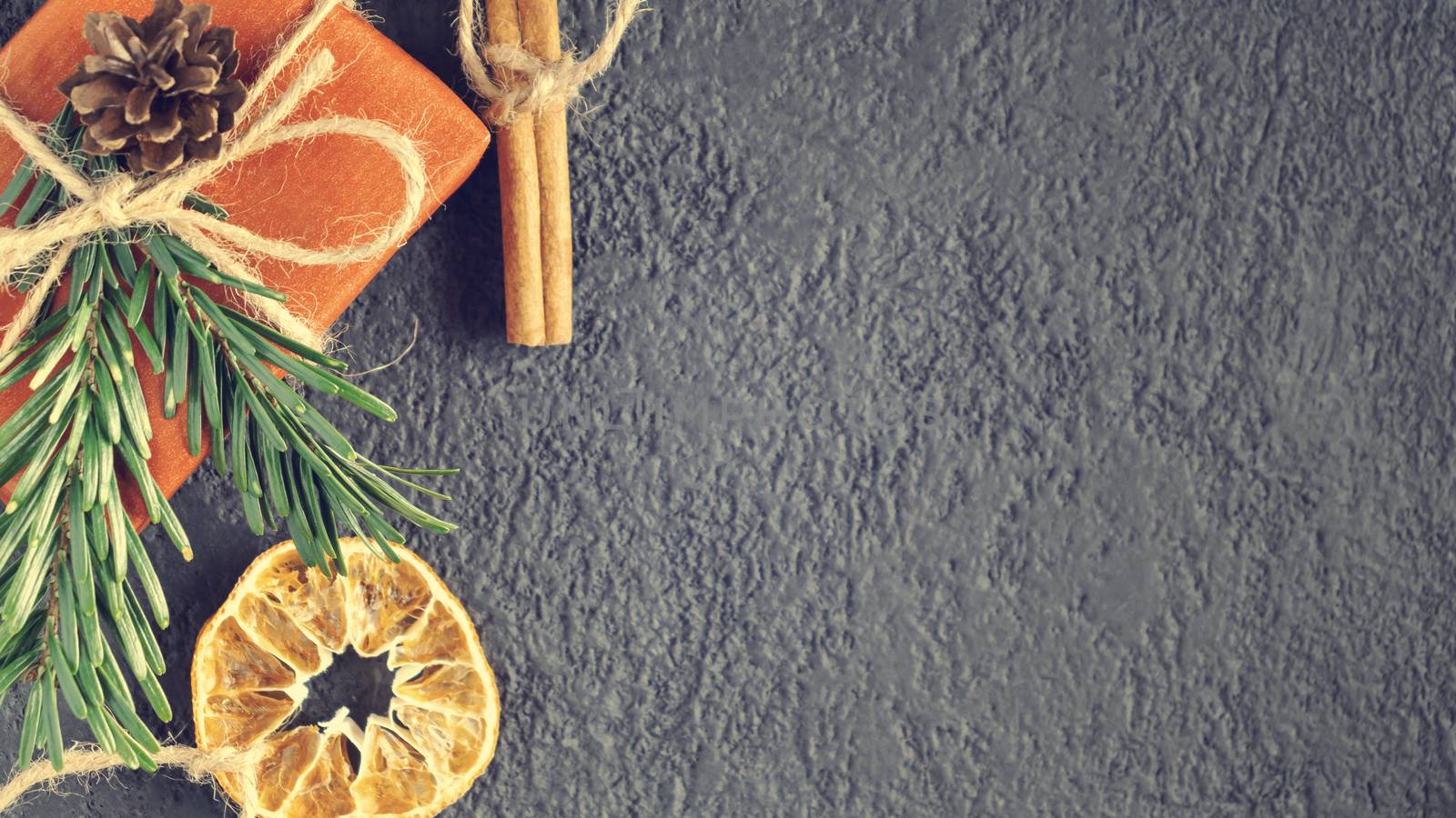 Christmas or New Year background with decorations from natural materials - Christmas tree twigs, cinnamon and dried orange.