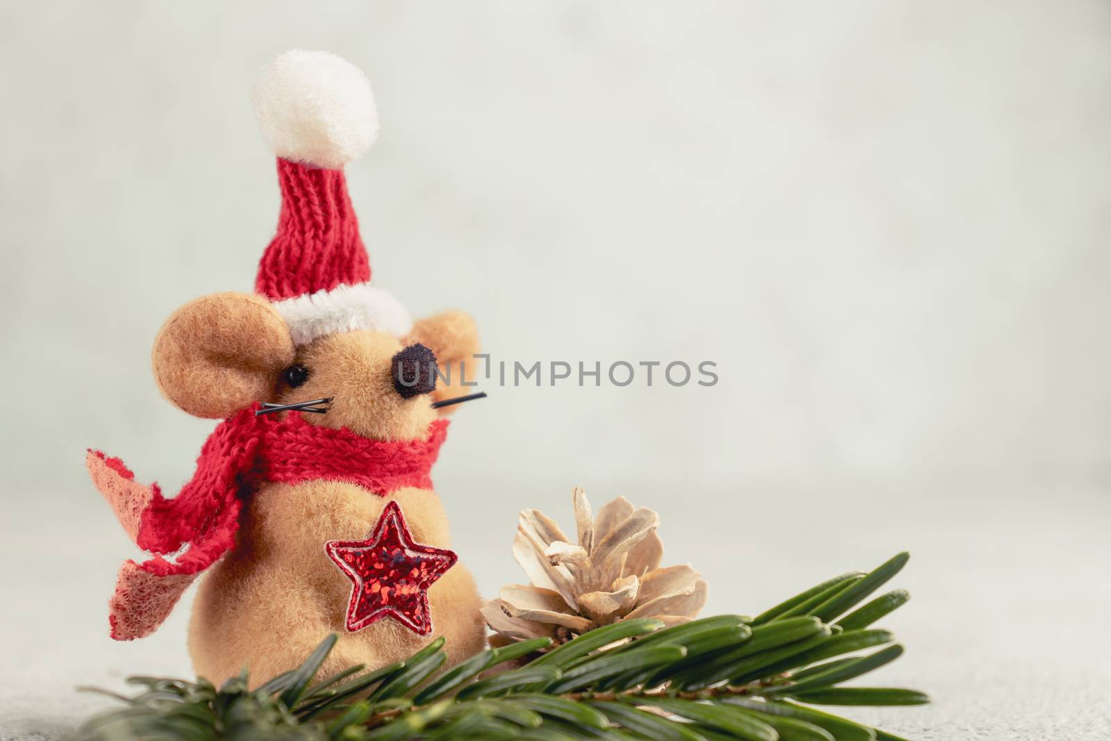 Little toy Christmas mouse, Christmas tree branch and cones on a gray table. Christmas composition with the symbol of 2020 according Chinese horoscope by galsand