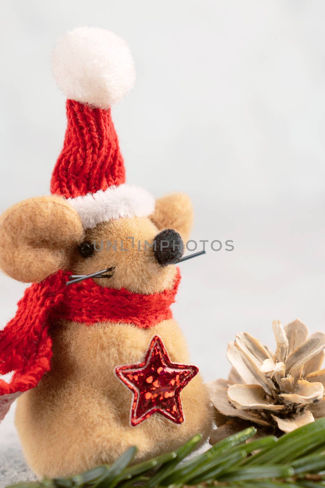 Little toy Christmas mouse and decorations on a gray table. Christmas composition with the symbol of 2020 according to the Chinese horoscope, horizontal banner with copy space.