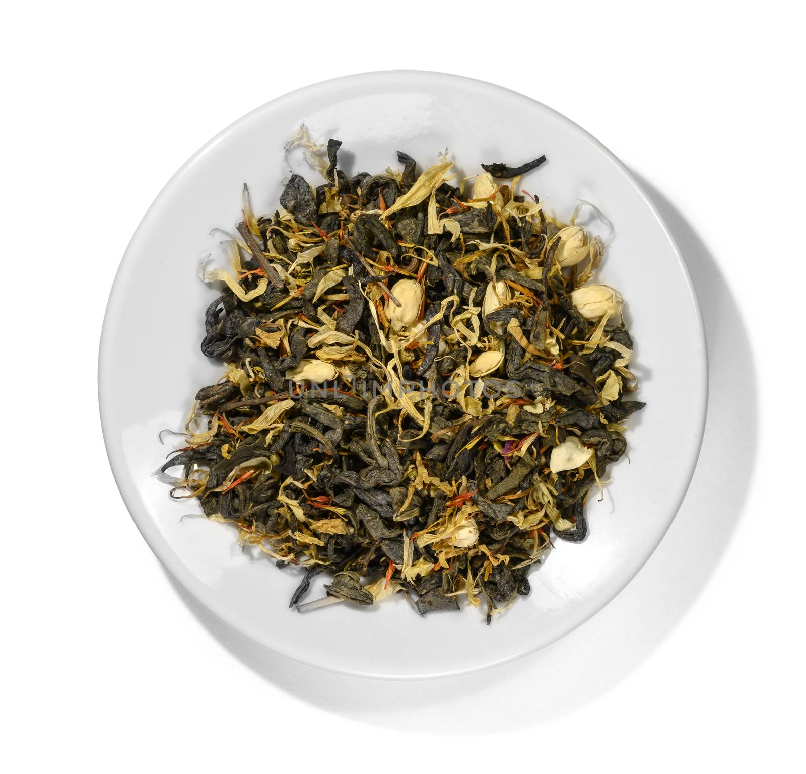 Green tea with aromatic additives. Top view on white background.