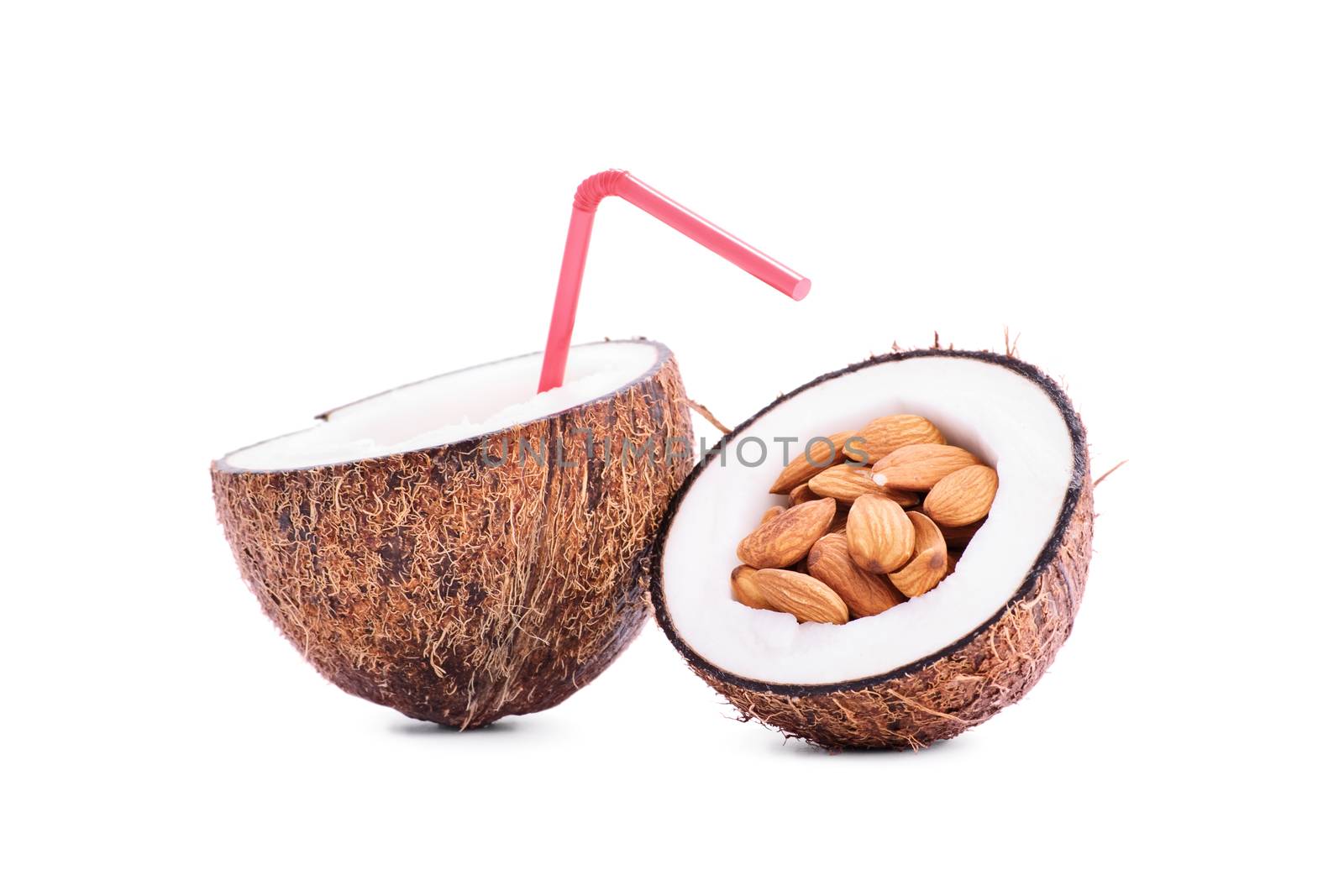 Sliced coconut fruit filled with almonds and coconut milk with a straw, isolated on white background.