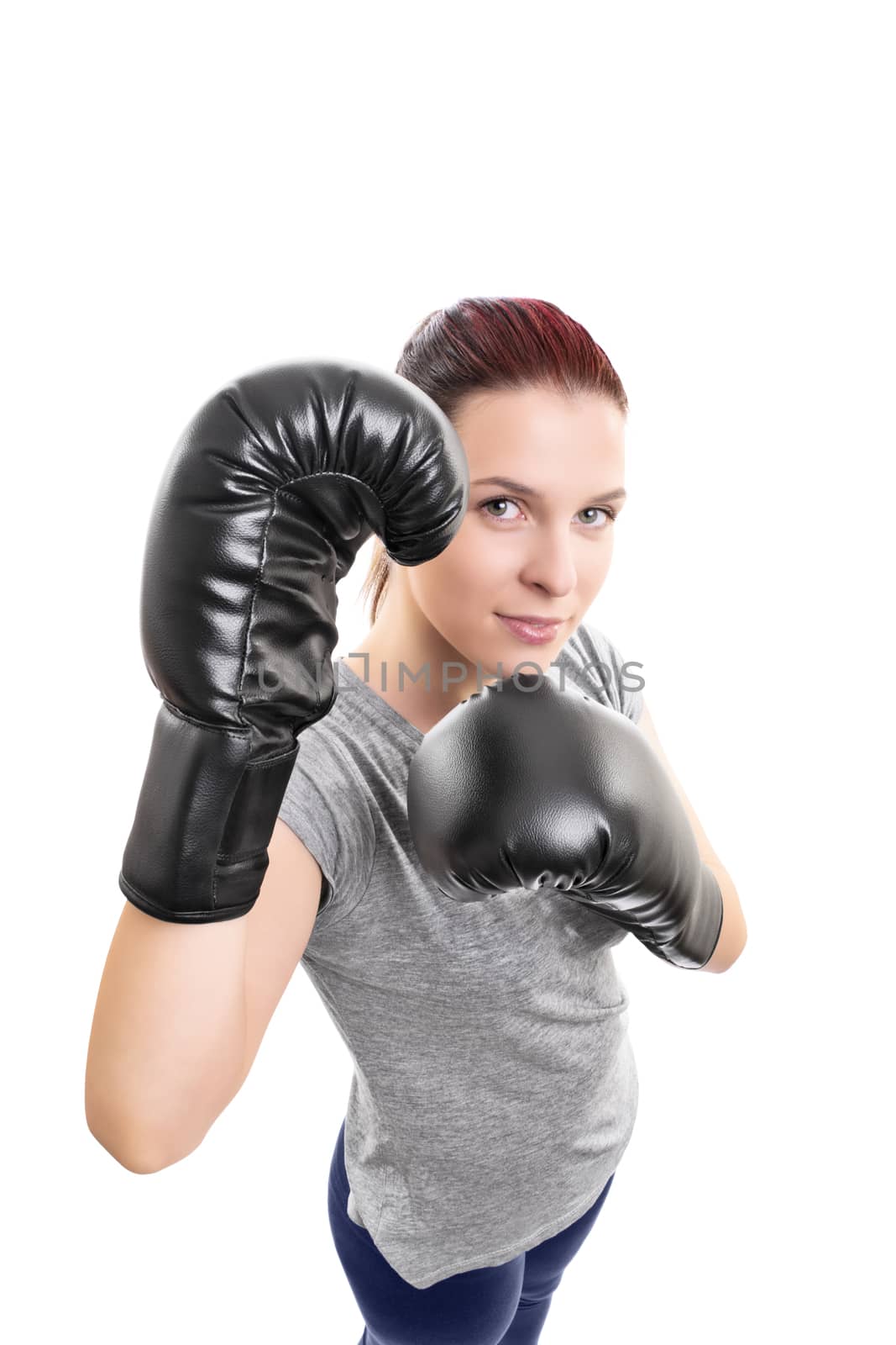 Top down portrait of a beautiful young woman with boxing gloves in a stance with raised arms looking up, isolated on white background.