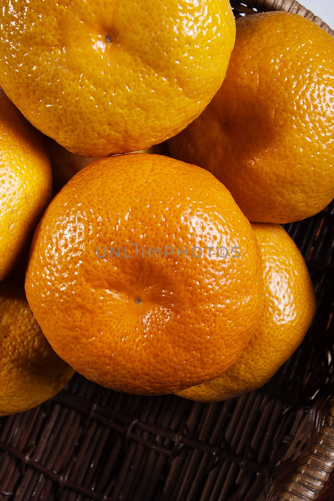 Ripe orange tangerines in a wicker basket