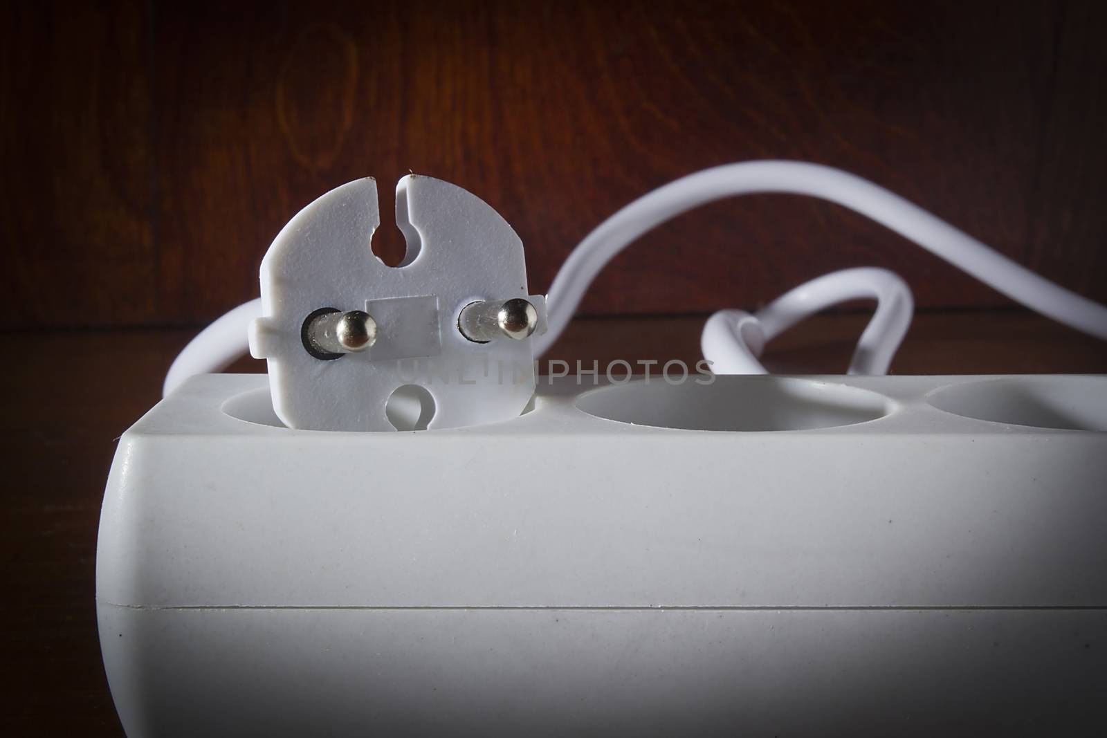 White extension cord on a wooden table