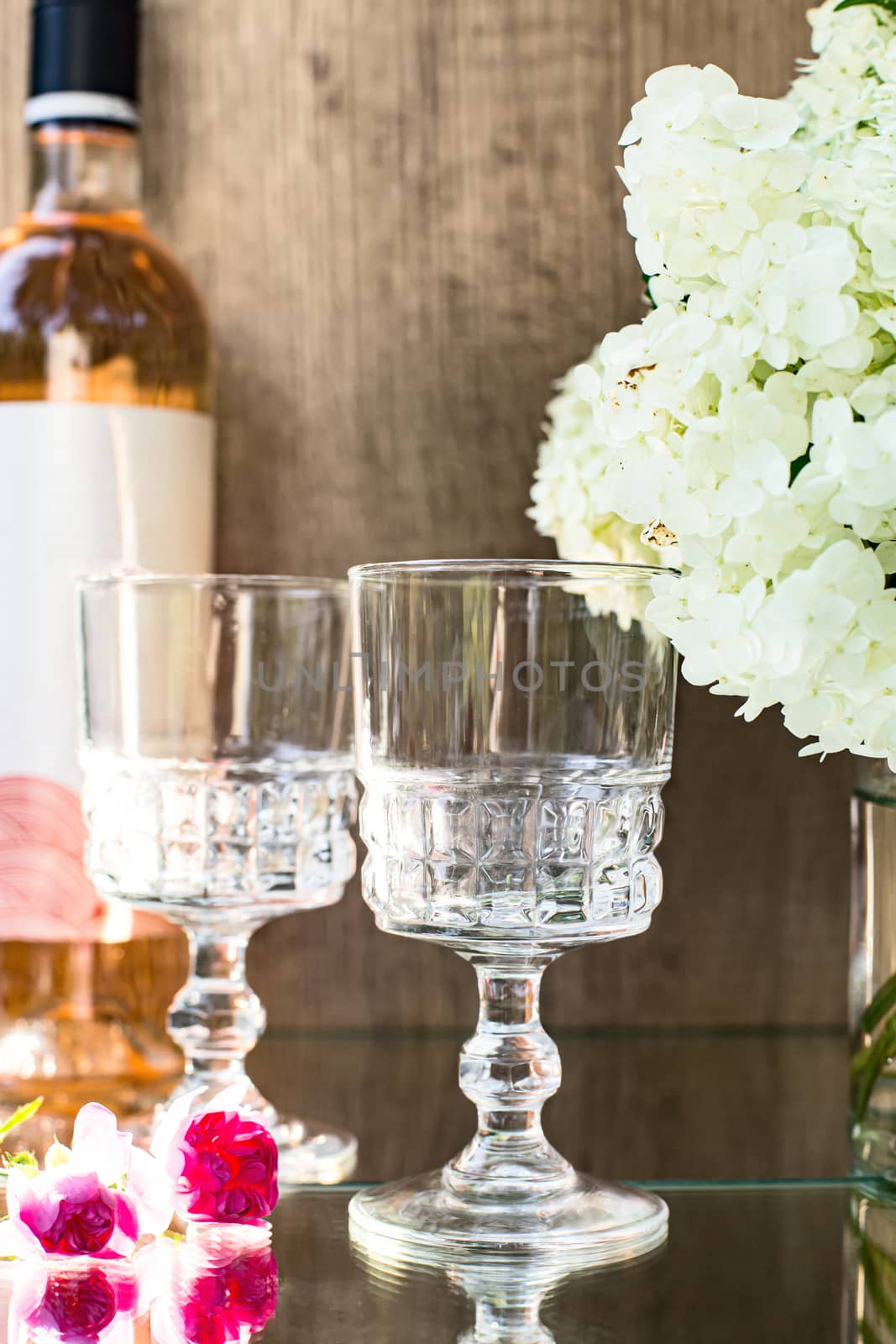 Rose blush wine in glasses. Bottle of rose wine with flowers on background. Prosecco.