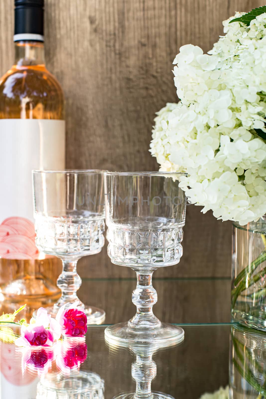 Rose blush wine in glasses. Bottle of rose wine with flowers on background. Prosecco.