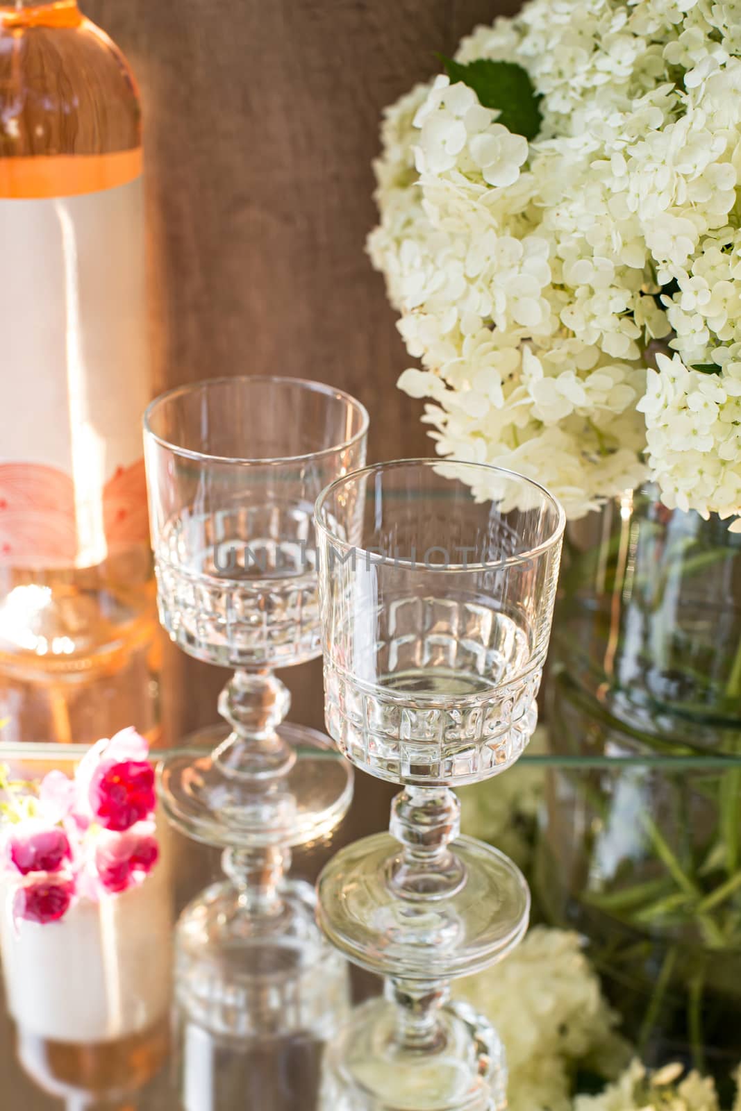 Rose blush wine in glasses. Bottle of rose wine with flowers on background. Prosecco.