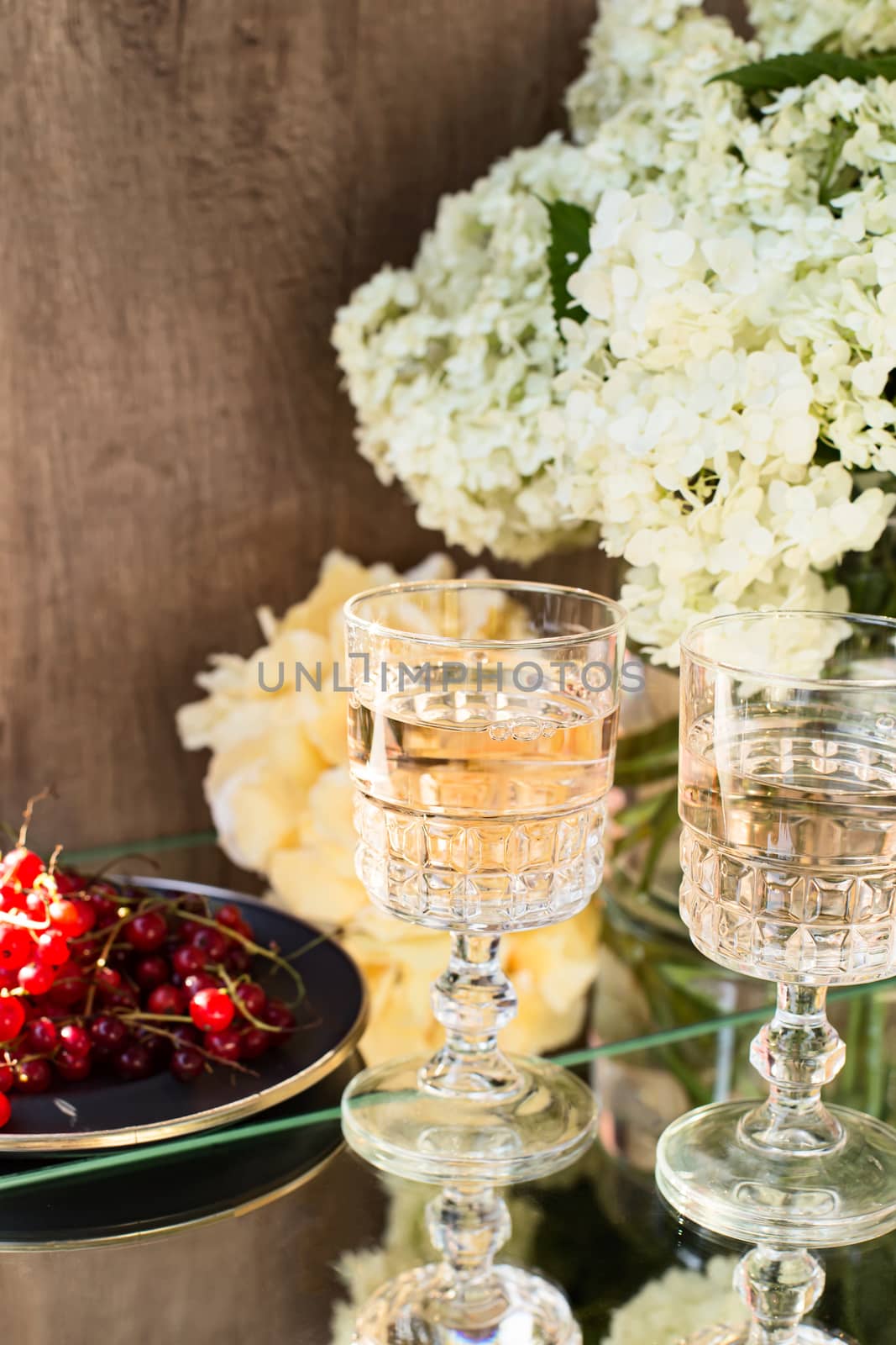 Rose wine in glasses. Rose wine on golden bottles background with flowers and fruits