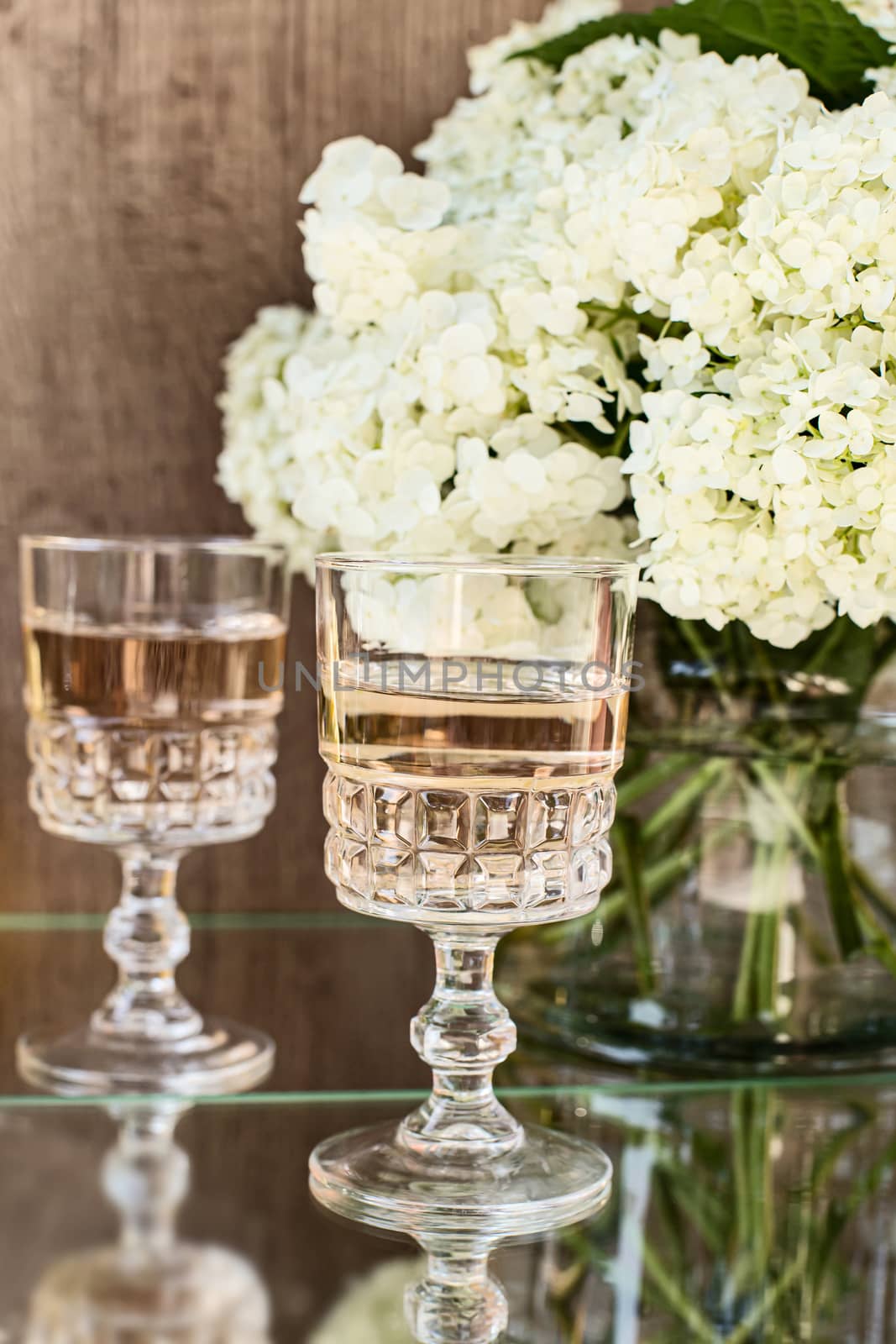 Rose blush wine in glasses. Bottle of rose wine with flowers on background. Prosecco.