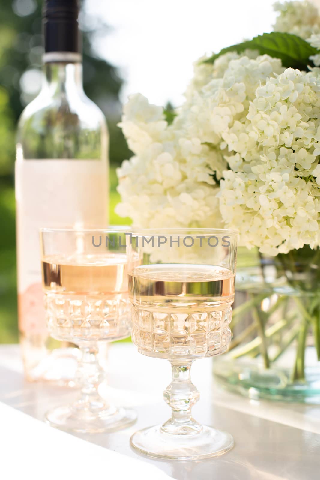 Rose blush wine in glasses. Bottle of rose wine with flowers on background. Prosecco.