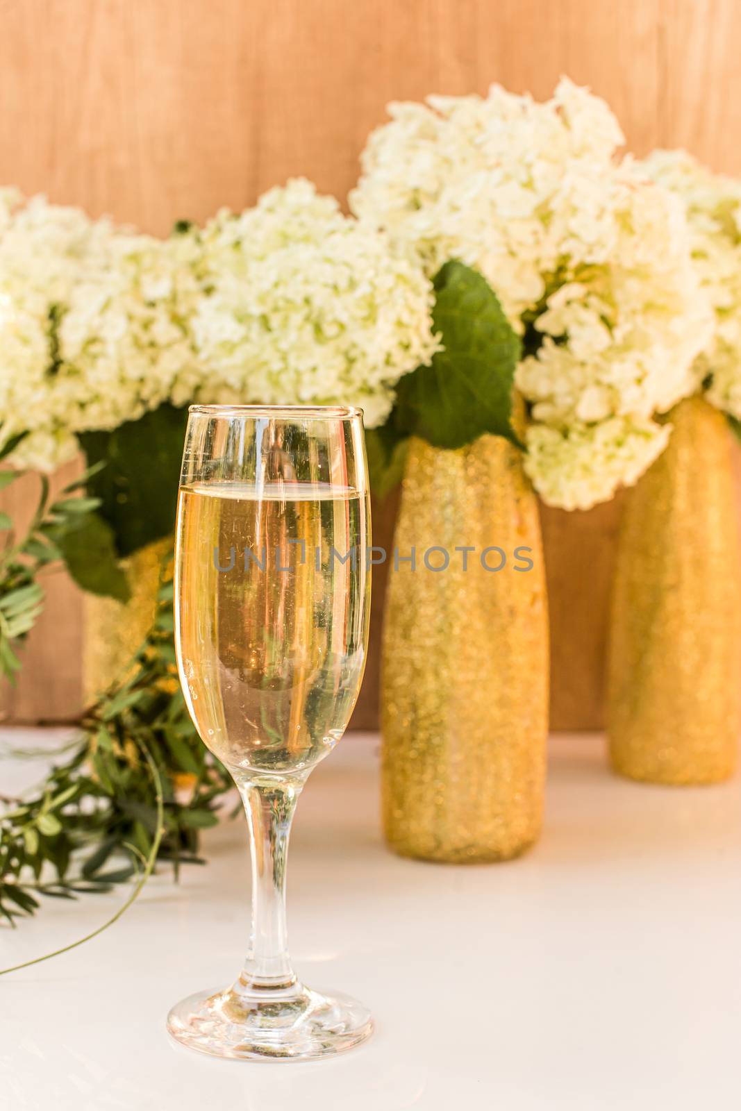 Rose wine in glasses. Rose wine on golden bottles background with flowers