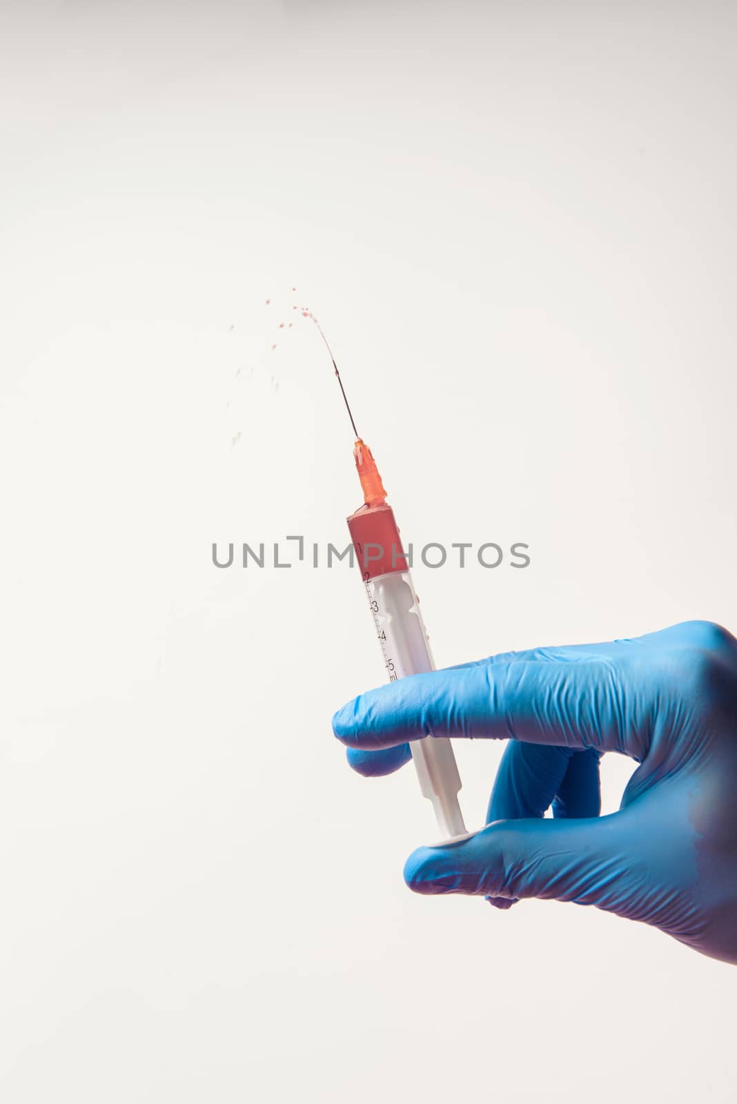Hand in glove with syringe on white background. Injections.
