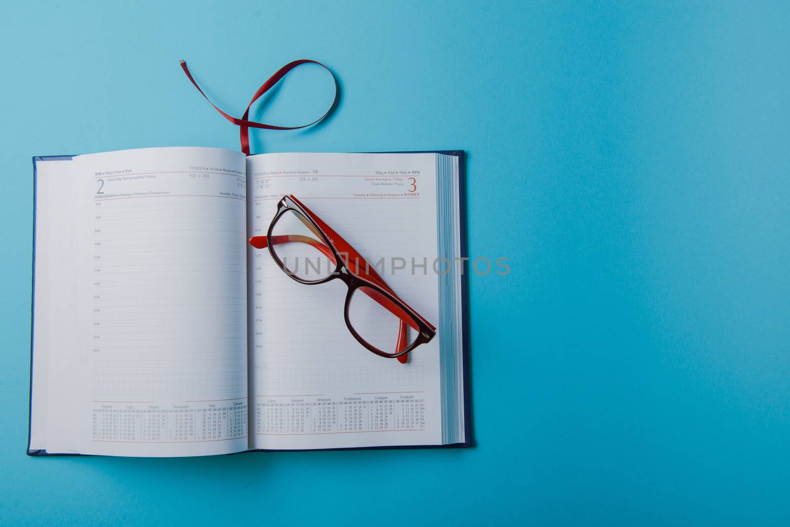 Business planning with copy space and office supplies. Red glasses on blue background