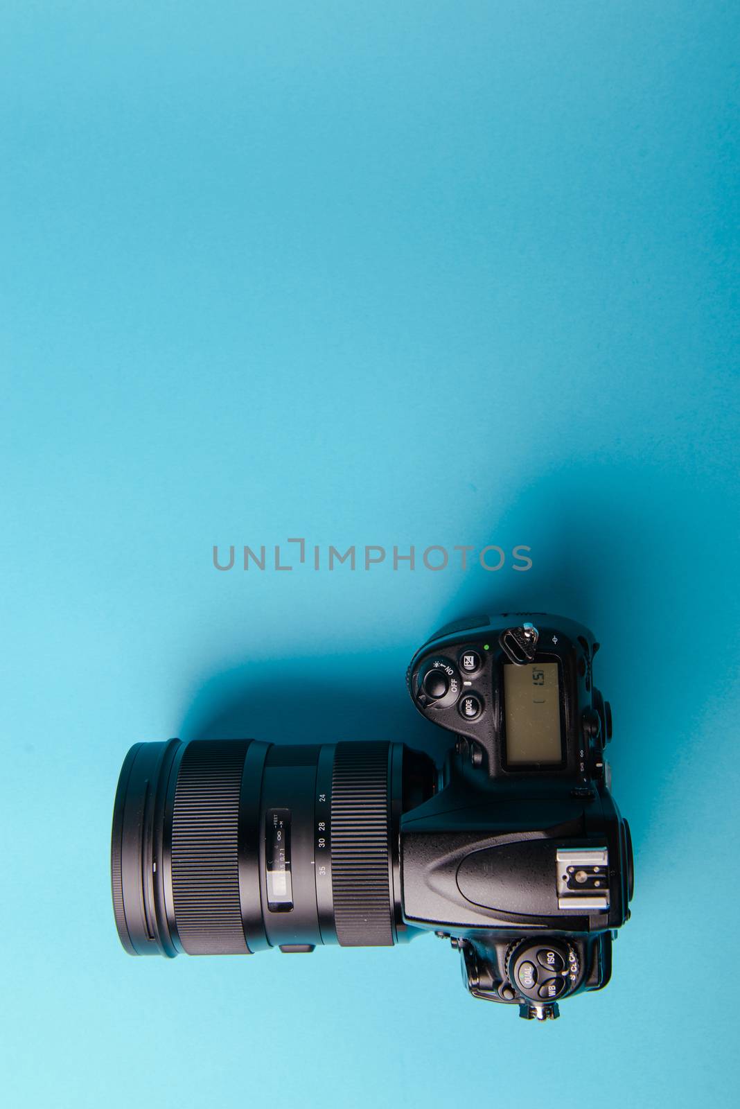 Professional modern DSLR camera against blue background