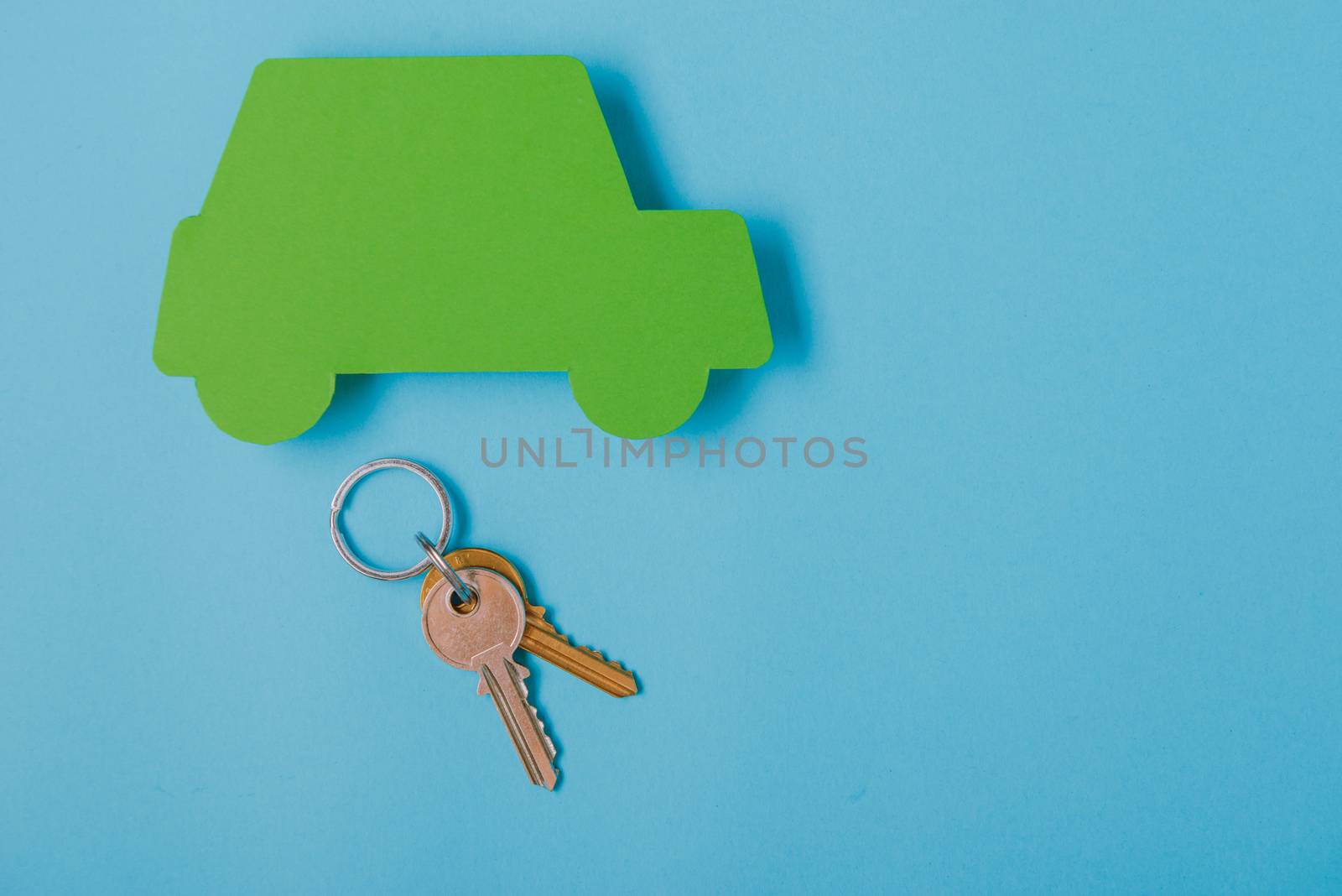 paper green cars figure with keys. top view on blue background