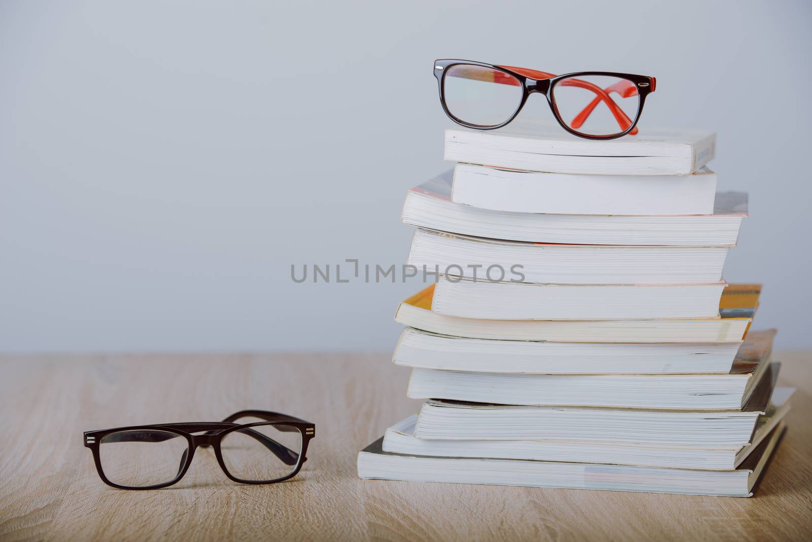 book and eyeglasses on wood background desk