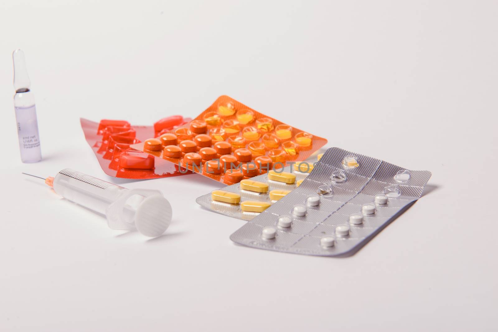 Multicolor tablets and pills capsules from glass bottle on blue background Heap of assorted various medicine tablets and pills. Health care Close-up Copy space.