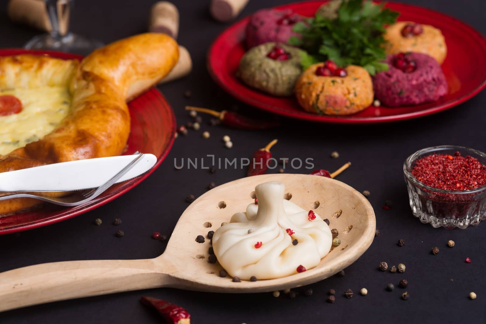 Georgian food on black table. khinkali, phali,  khachapuri with tomatos and adjika