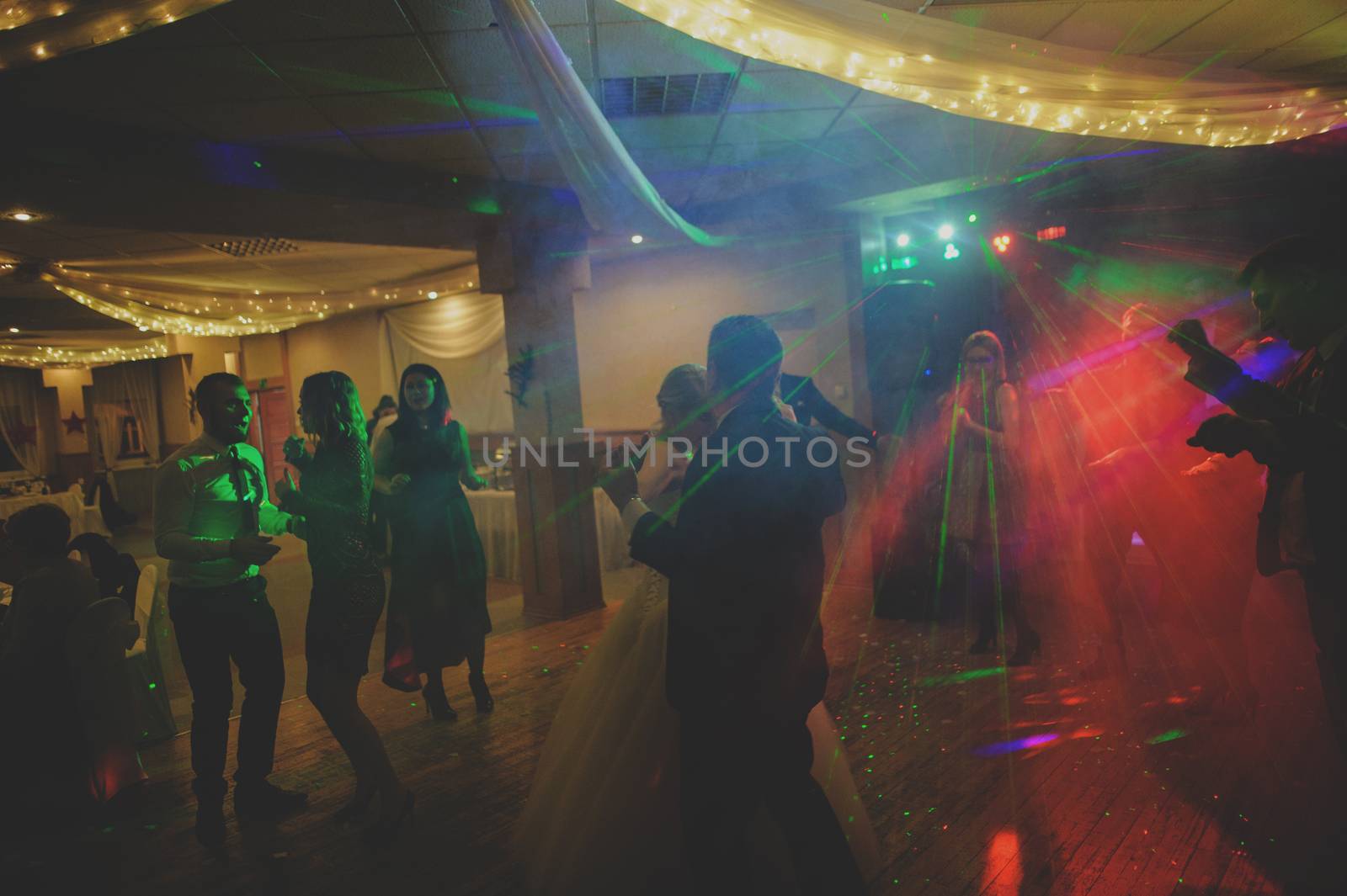 Bride and groom dancing the first dance at their wedding day. Guest on the dancefloor