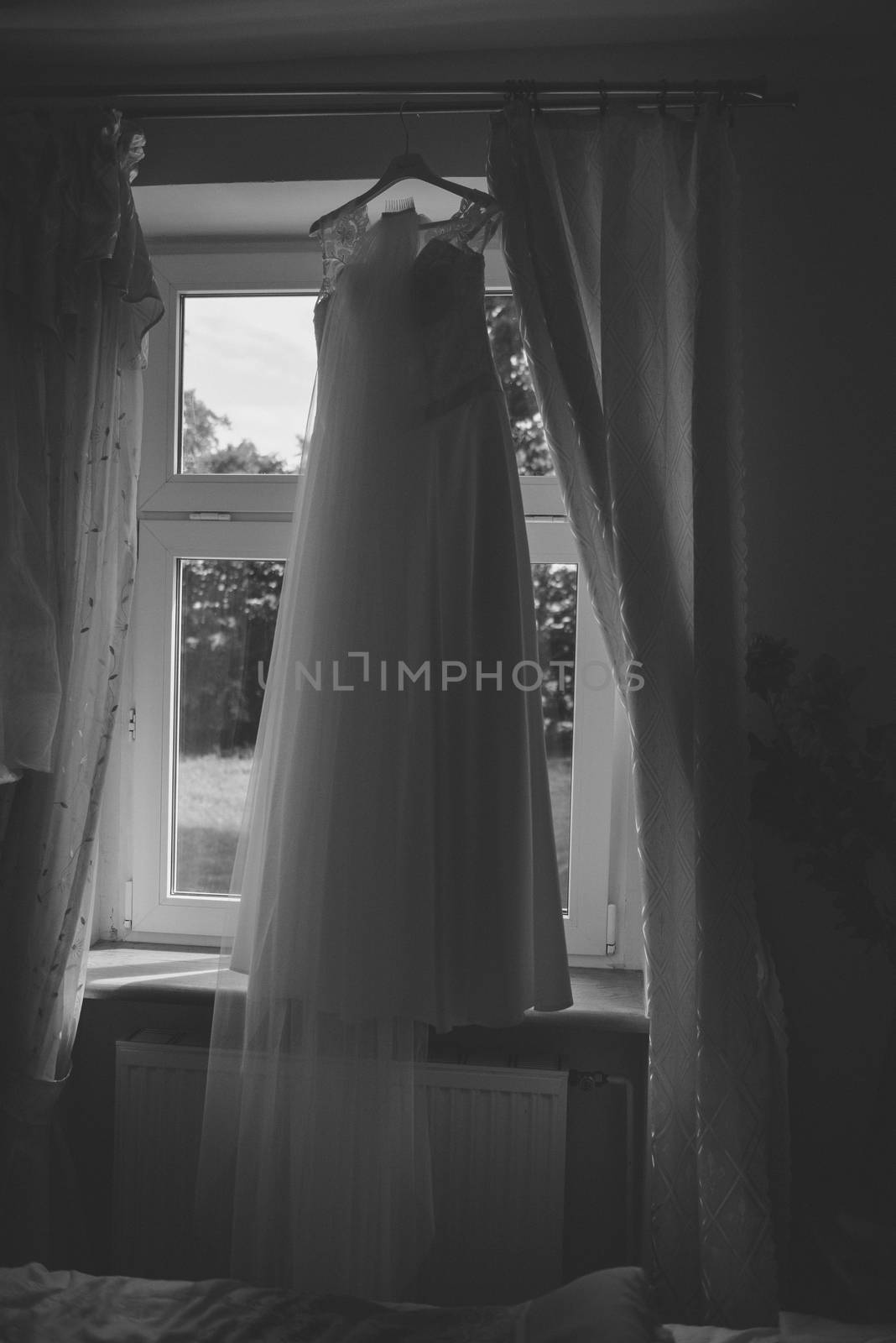 Bridesmaid helping slender bride lacing her wedding white dress, buttoning on delicate lace pattern with fluffy skirt on waist. Morning bridal preparation details newlyweds. Wedding day moments, wear.