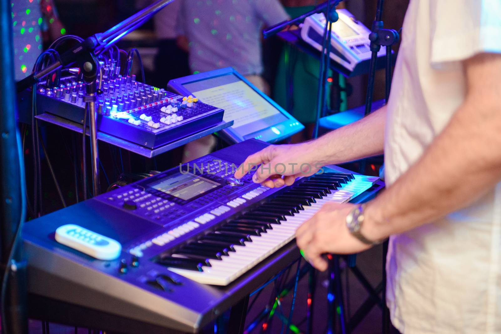 DJ plays music at wedding party. Colorful light rays.