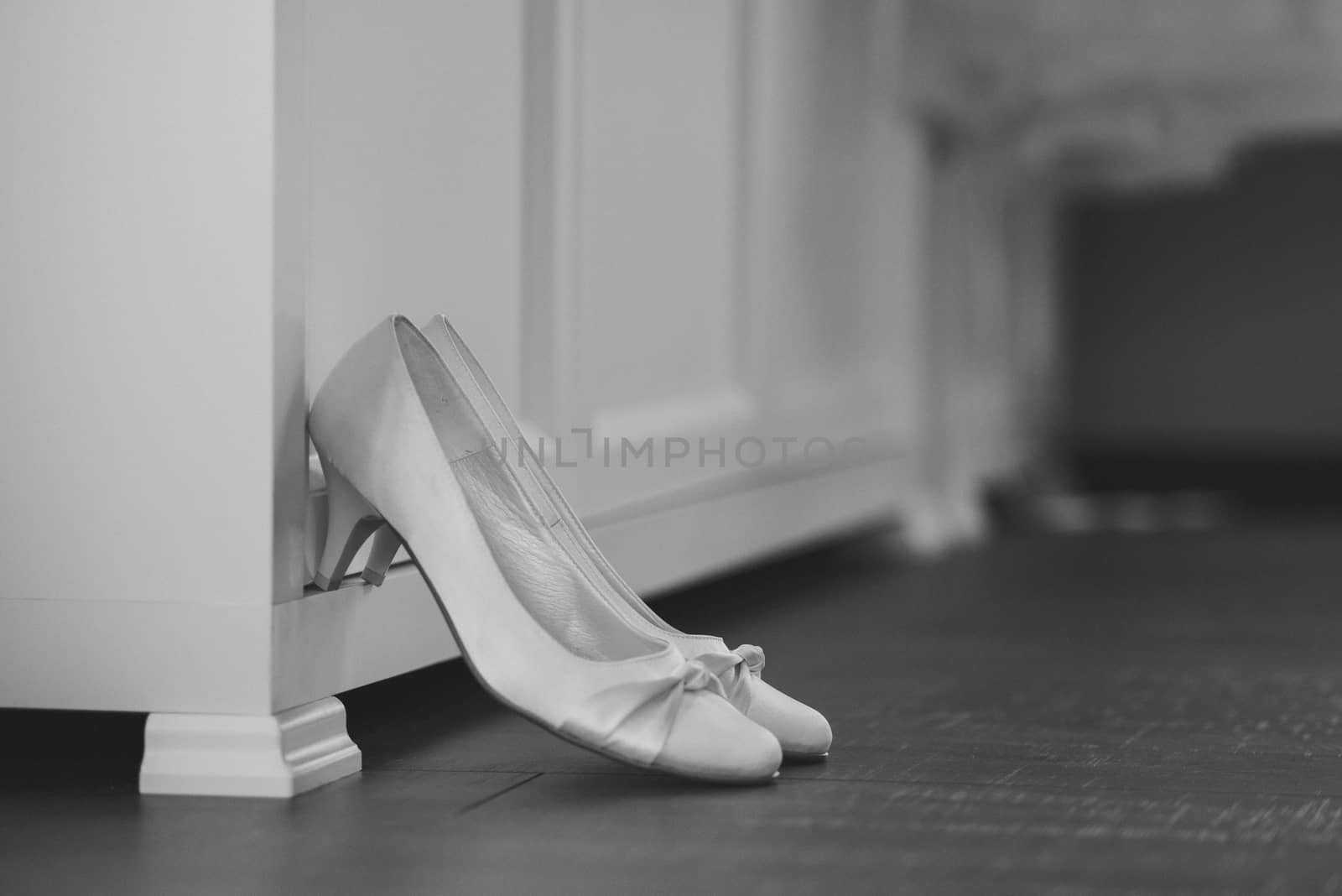 The bride shows white wedding shoes. Wedding detail. Close up