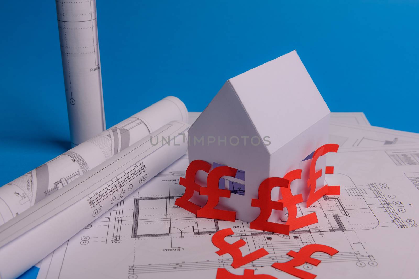 White family paper house , british pound money symbol , house projects plan and blueprints on mint background paper. Minimalistic and simple concept, style. Vertical orientation. View from above. copy space