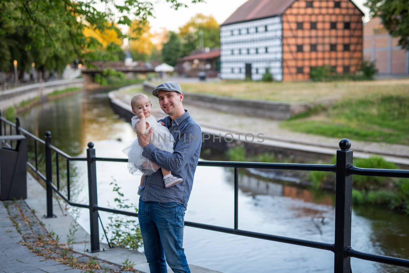 Happy loving family. Father and his daughter child girl playing and hugging outdoors. Cute little girl hugs daddy. Concept of Father's day. Authentic image.