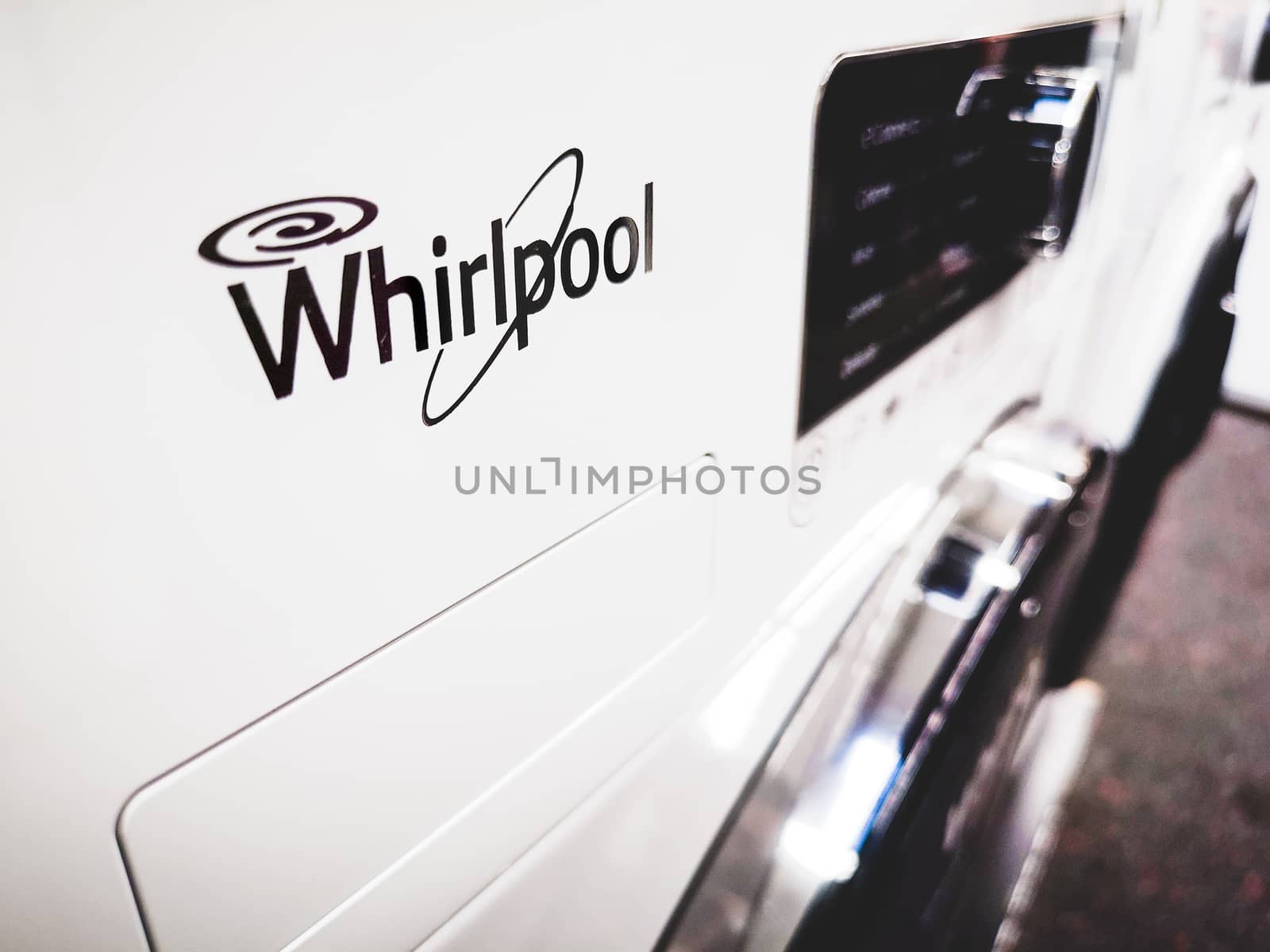 Close up to a Whirlpool brand logo on a white washing machine by LucaLorenzelli