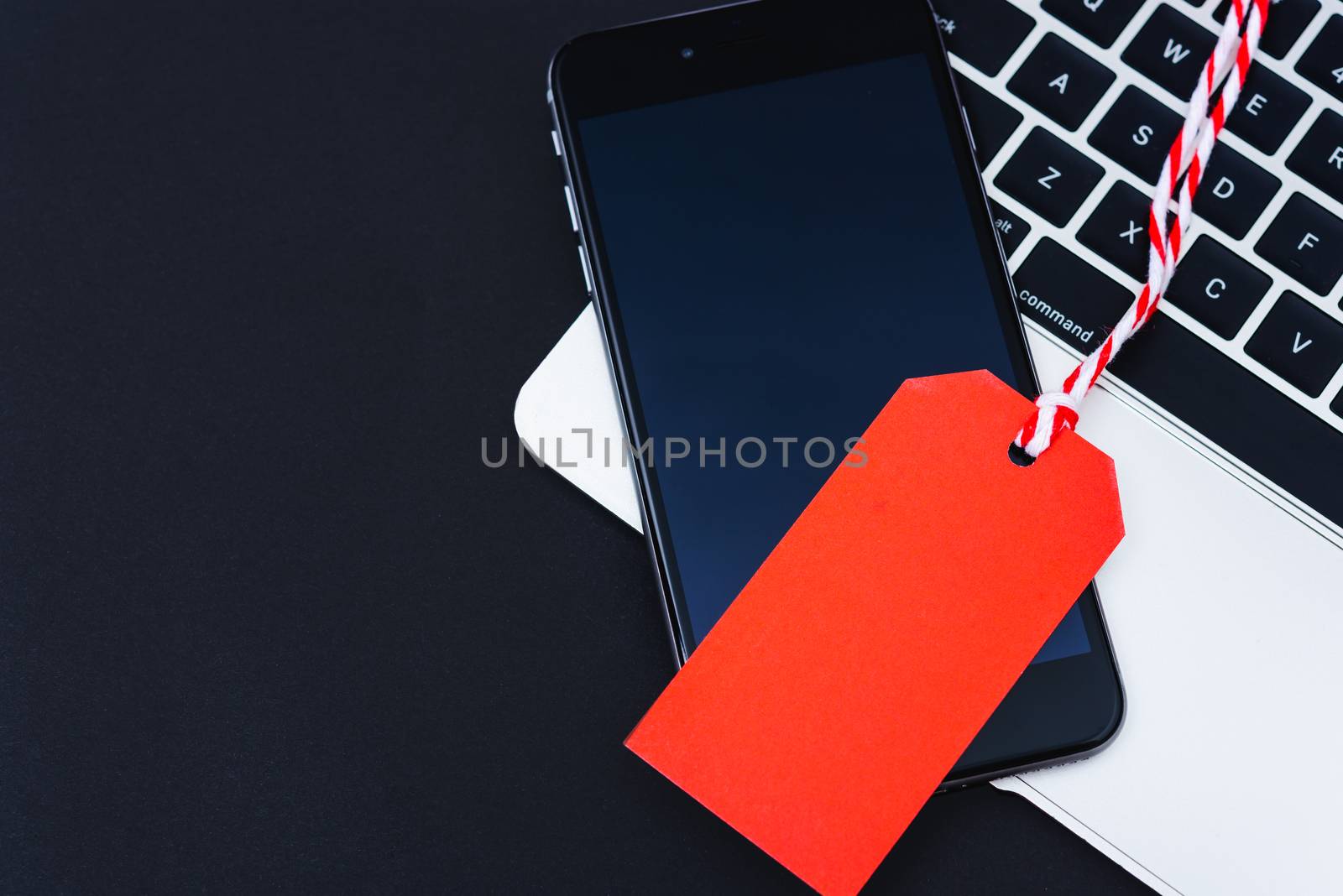 Blank Red tag have mobile smart phone over laptop computer with red background