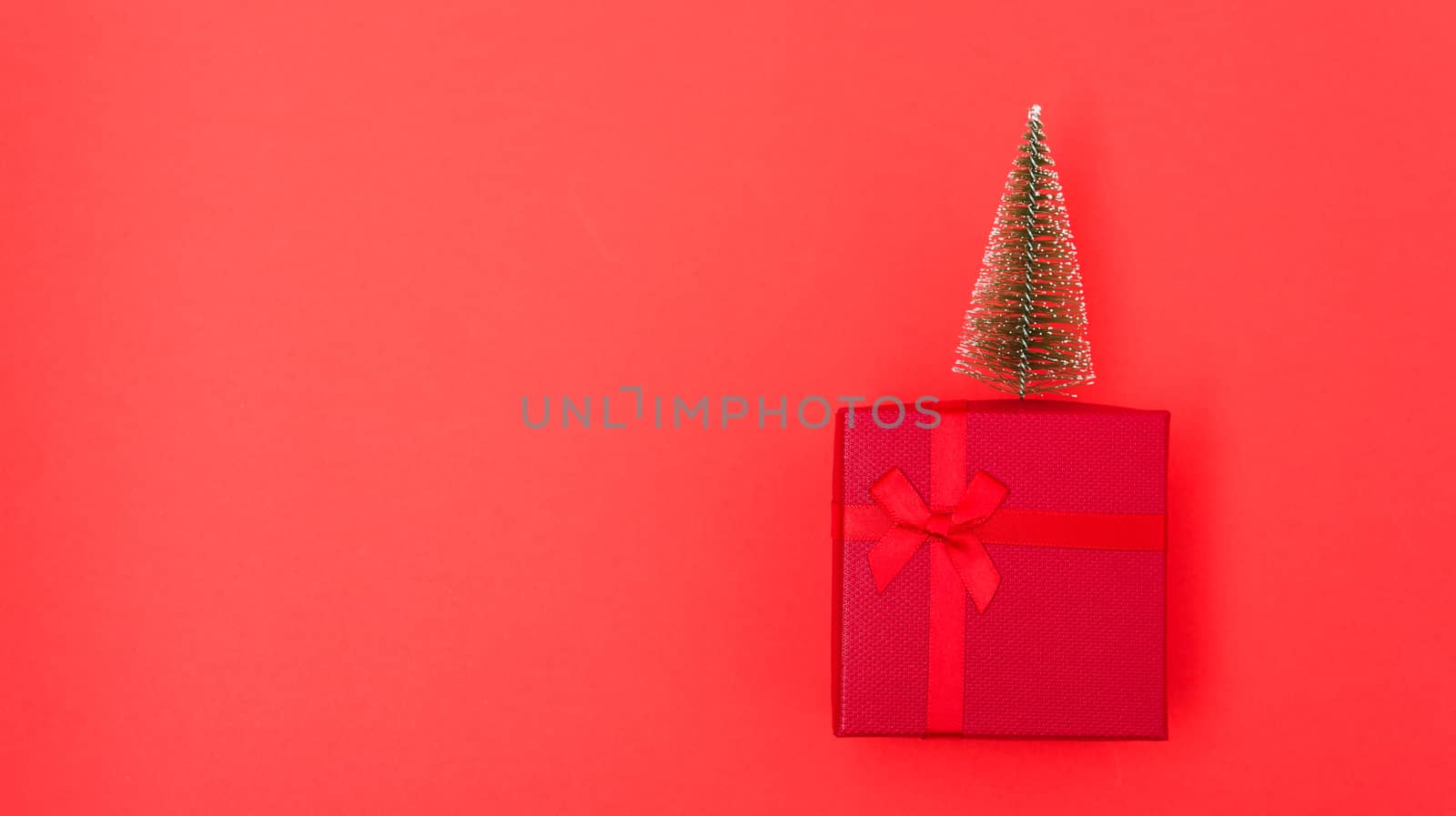 New Year, Christmas Xmas holiday composition, Top view red gift box with green fir tree branch over box on red background