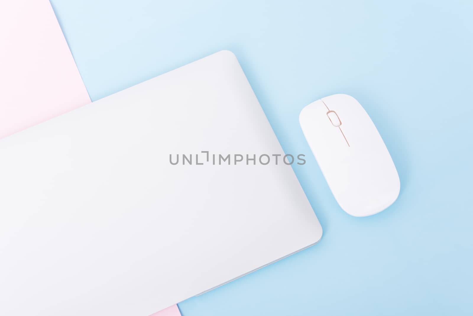 Top view close cover laptop computer notebook and wireless mouse isolated on blue background