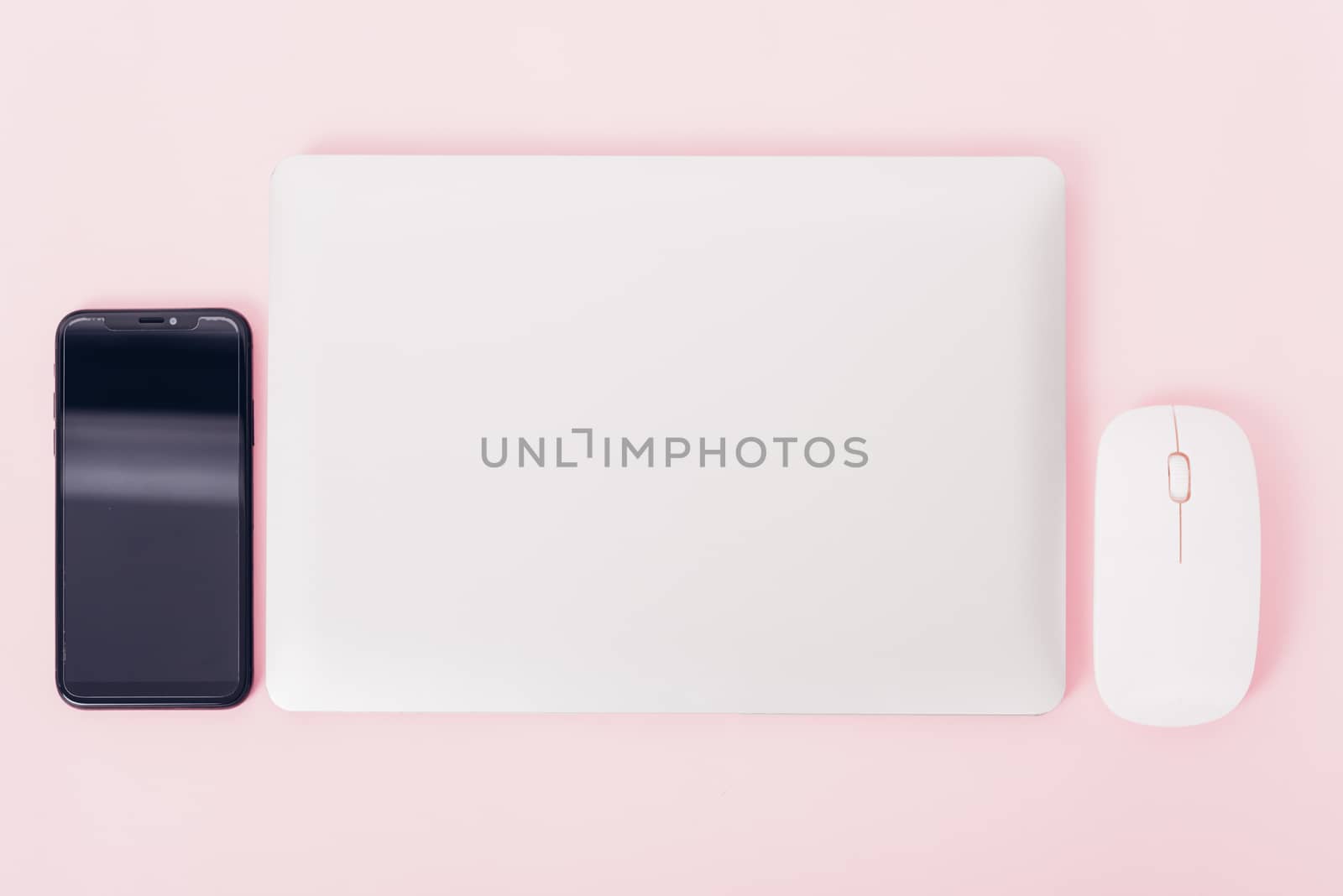 Top view of modern technology smart phone mobile and computer laptop close cover on pink background with copy space